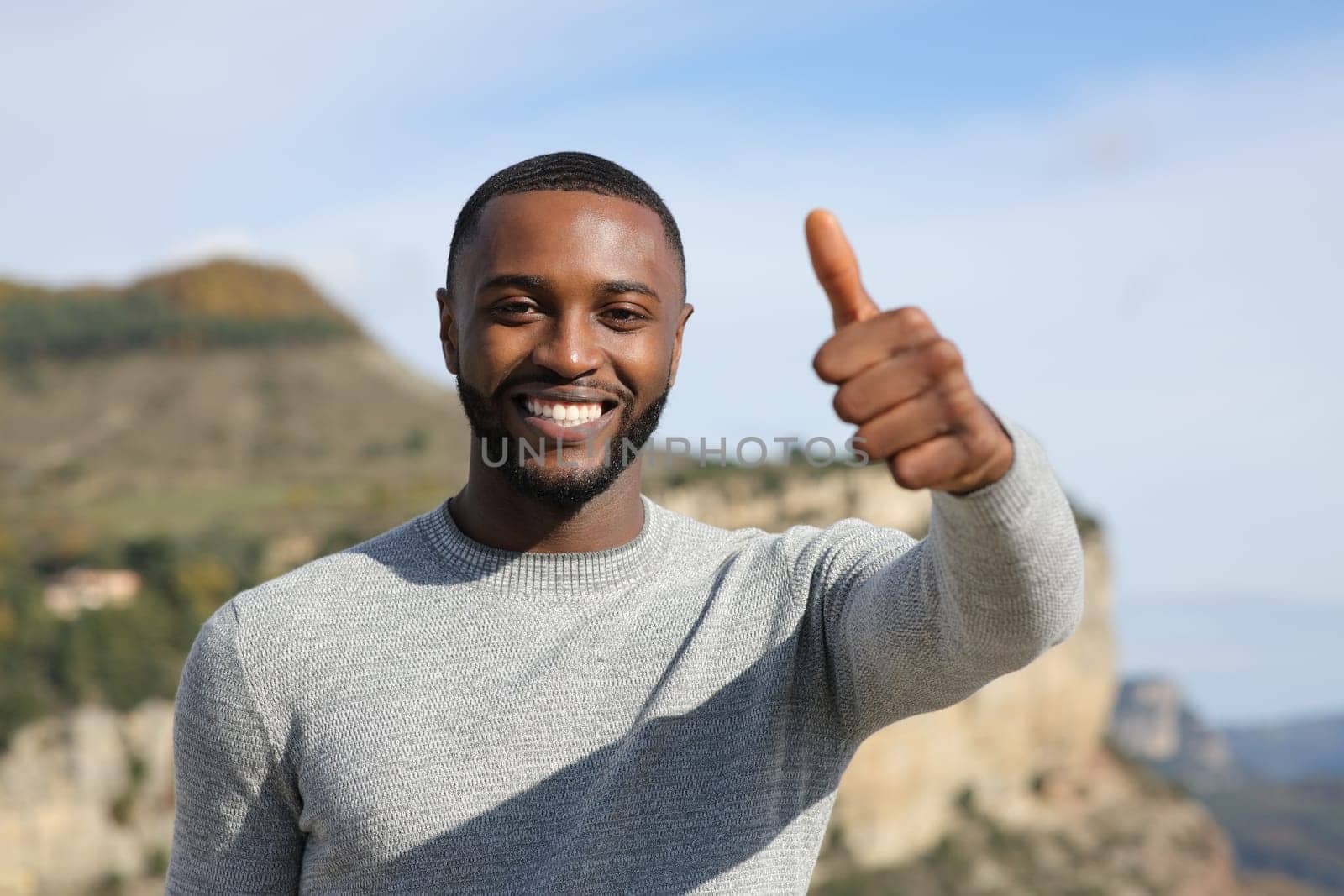Happy man with black skin gesturing thumb up