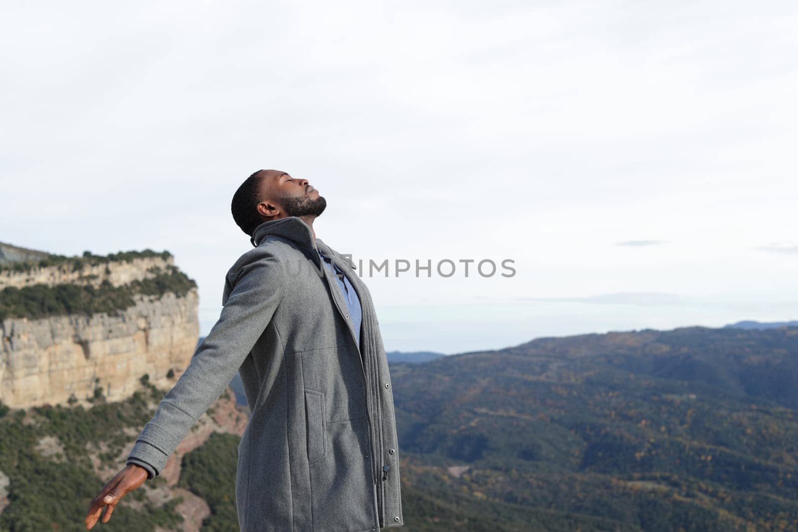 Man with black skin breathing fresh air in winter