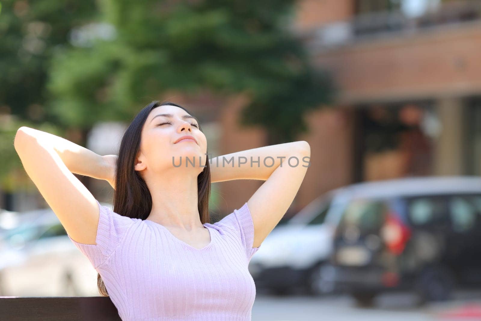 Relaxed asian woman sitting on bench in the street