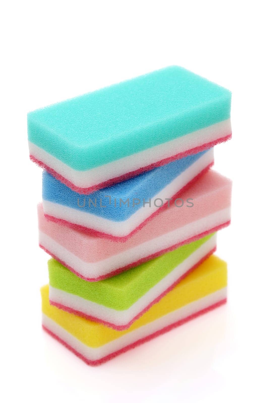 Stacked color rectangular sponges for washing dishes and cleaning in kitchen on white background