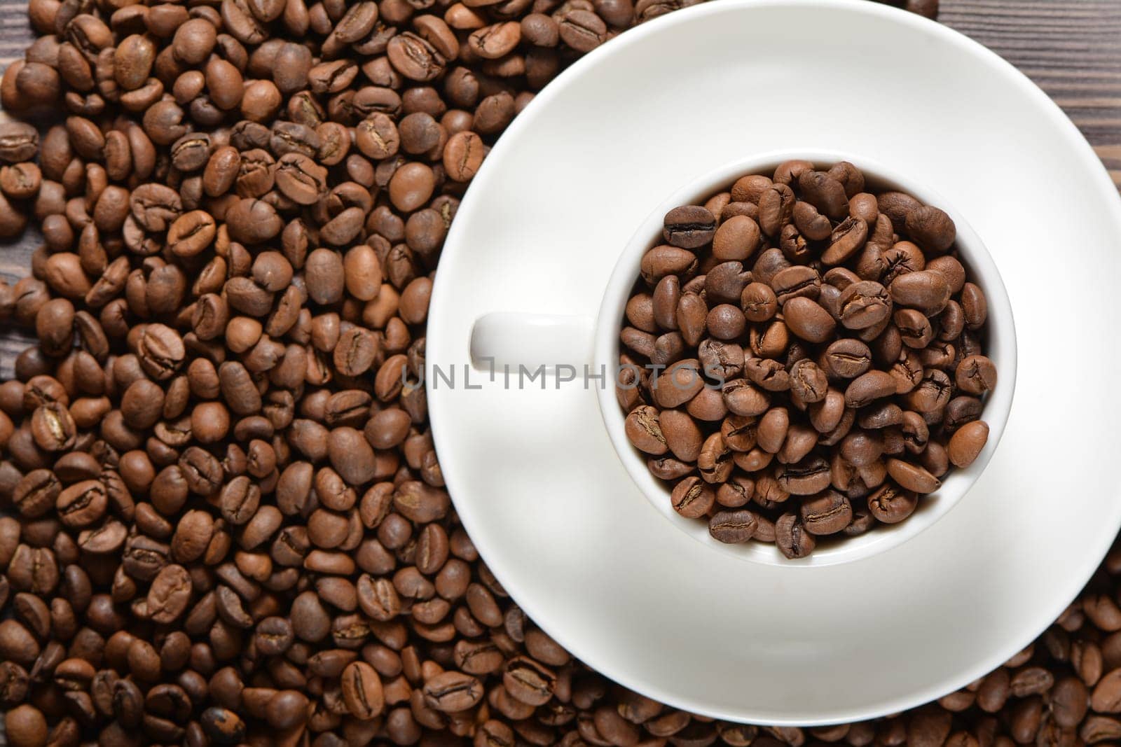 White coffee mug filled with coffee beans. High quality photo