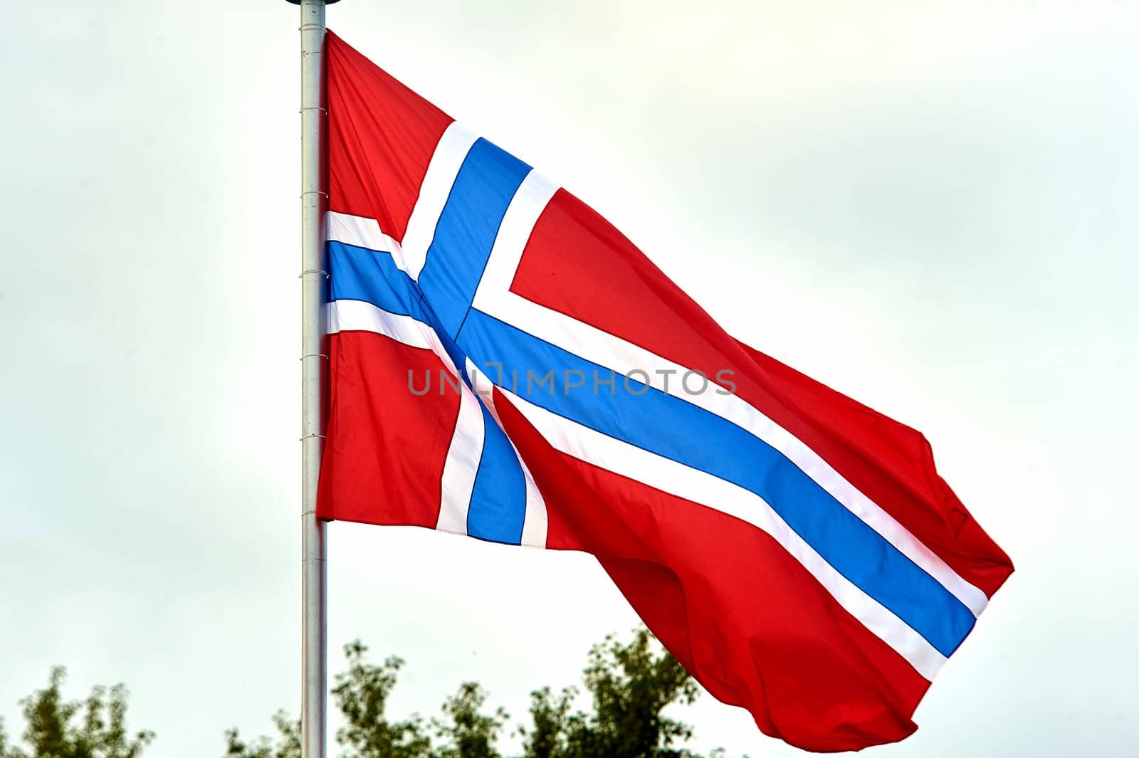 The flag of Norway hangs on the flagpole. High quality photo