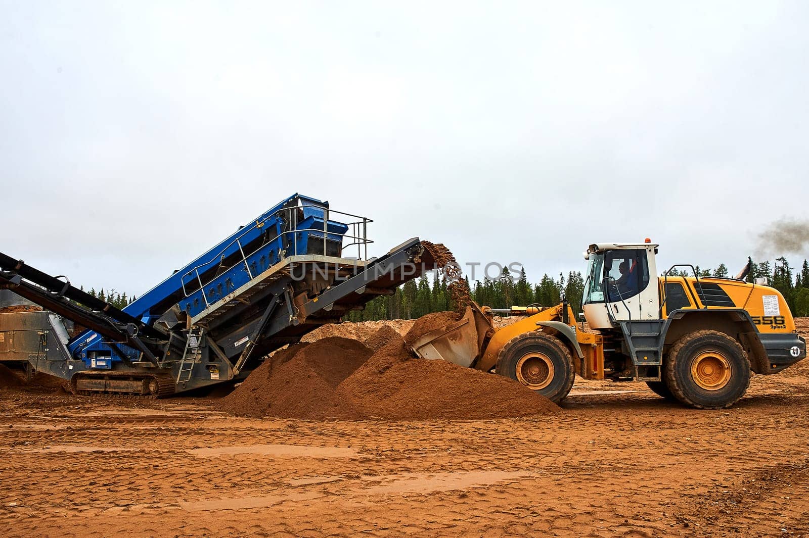 The front loader in the quarry collects a bucket of sand. High quality photo