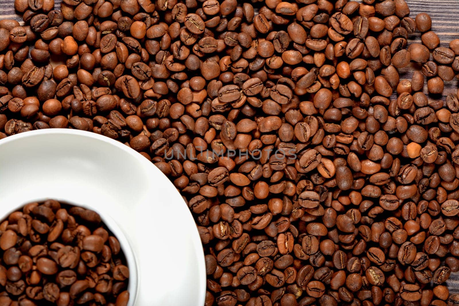 White coffee mug filled with coffee beans. High quality photo