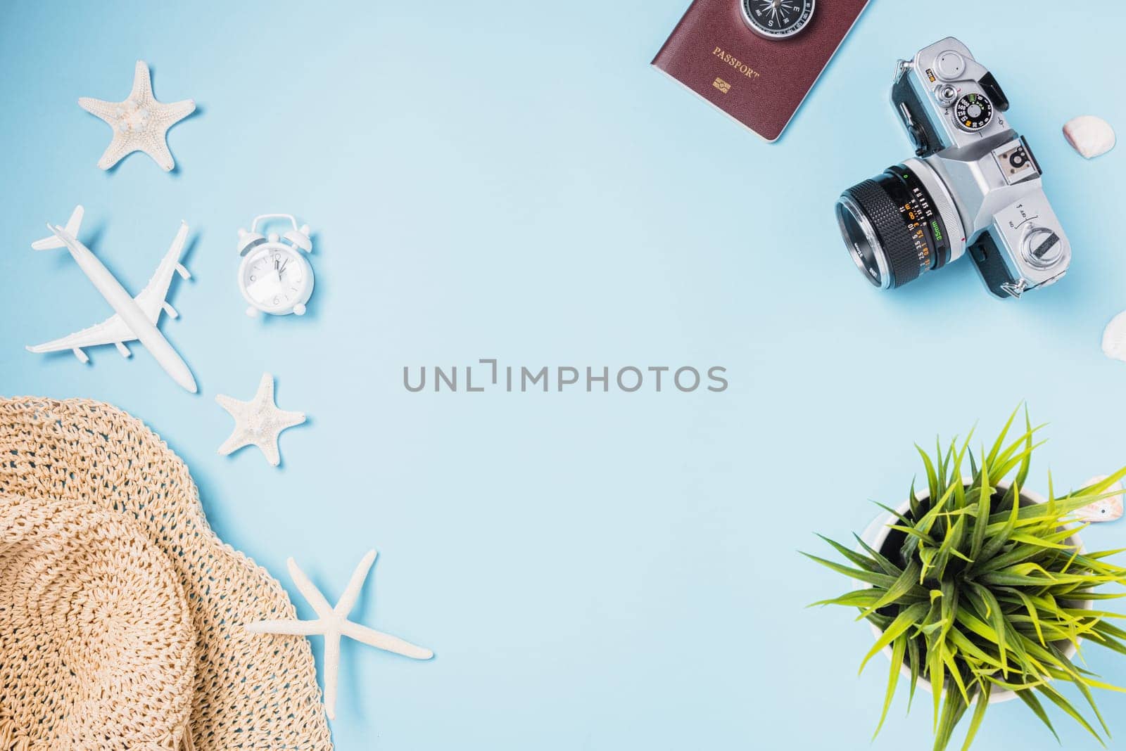 Flat lay top view mockup retro camera films, airplane, starfish, shells, hat traveler tropical accessories on a blue background with copy space, Business trip, and vacation summer travel concept