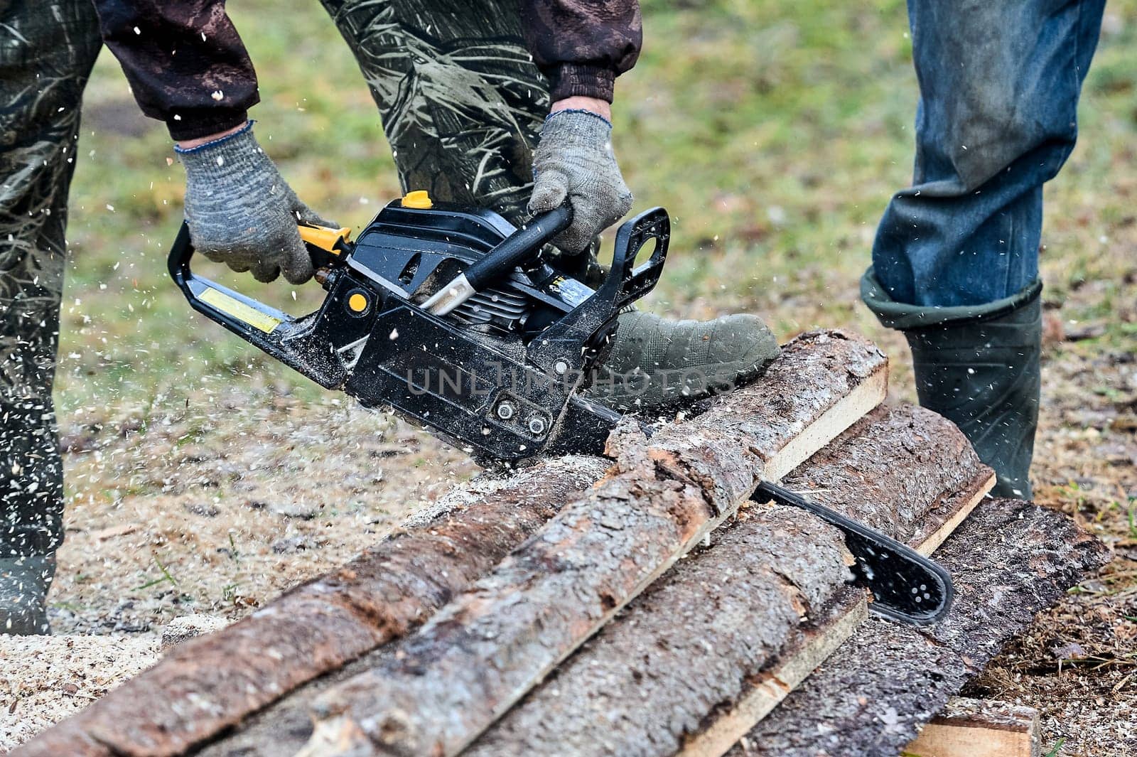 a chainsaw is used to cut wood outdoors. High quality photo