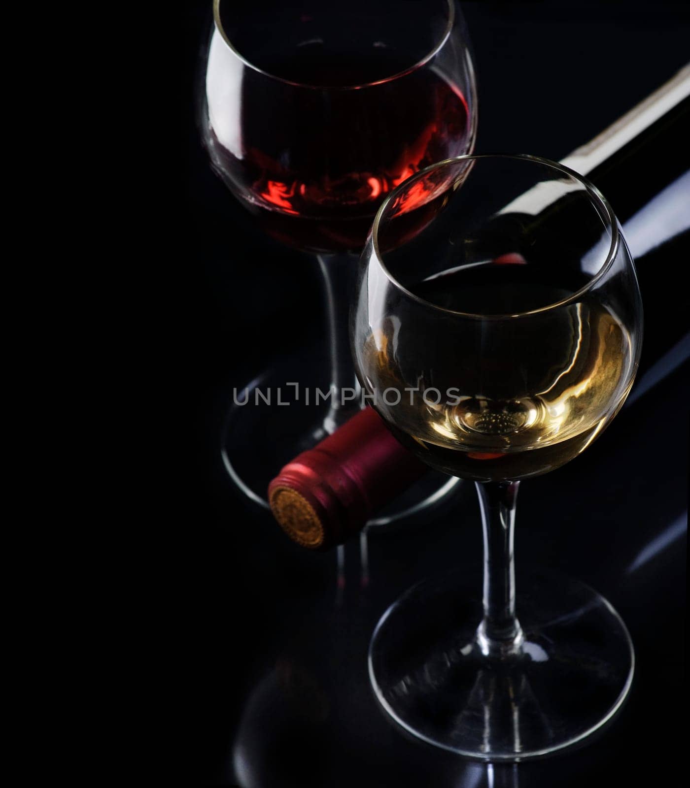 .Glass of red and white wine on black background