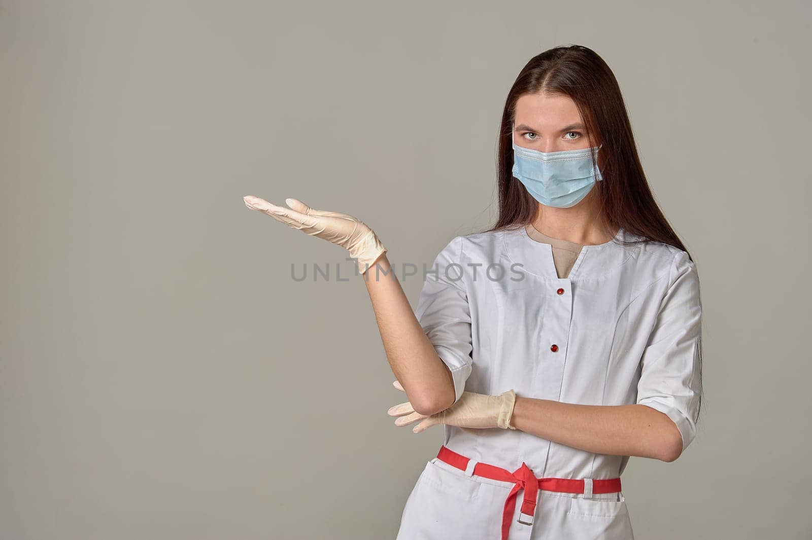 A female doctor in a medical mask points to an empty place, copy space. High quality photo