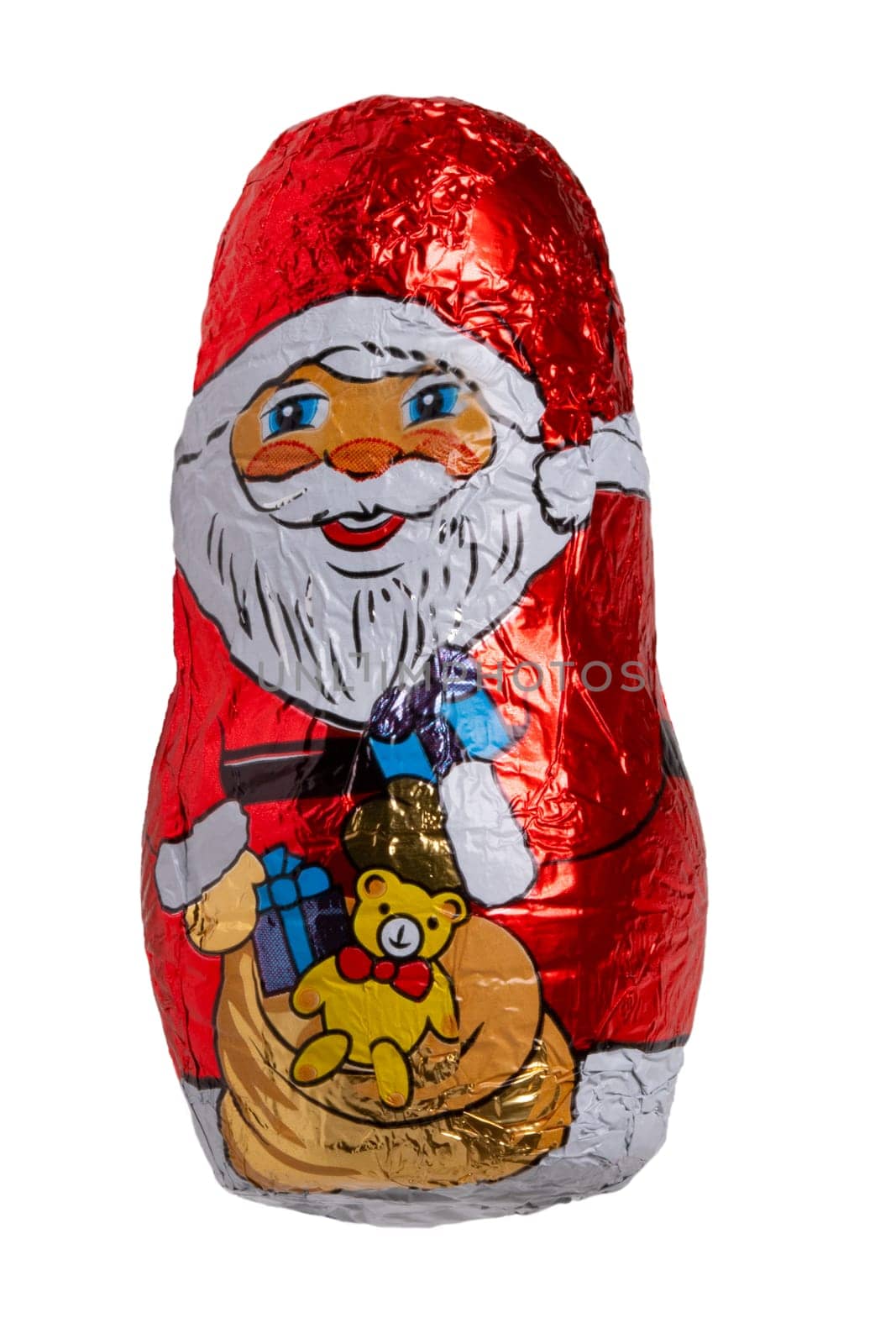 Chocolate Santa isolated. Close-up of a cheerful wrapped chocolate Father Christmas or the good Saint Nicholas figure isolated on a white background. Macro photography.