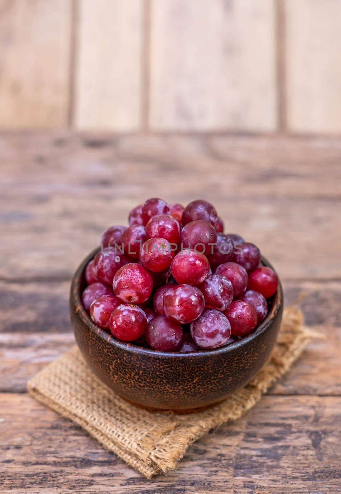 Red grape fruit in bowl isolated on wooden background