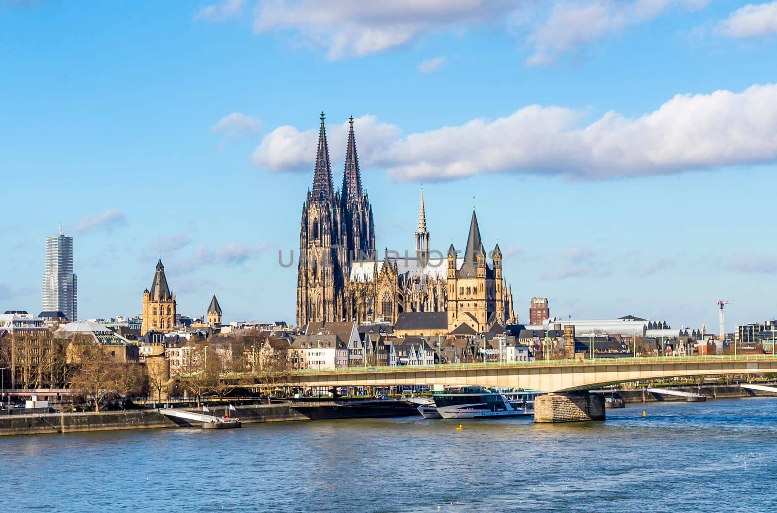 COLOGNE, GERMANY - FEB 12, 2014: Cologne skyline with cathedral  and ships on river Rhine, the central transportation route from north to south Germany