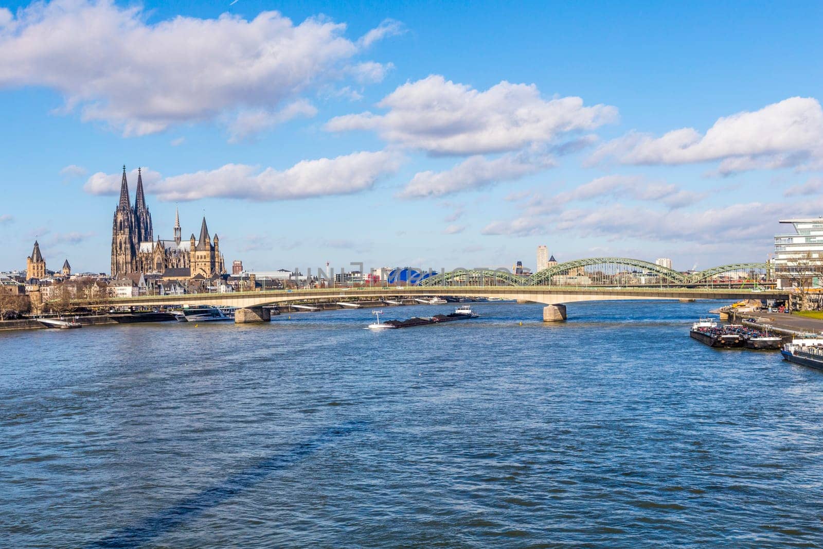 COLOGNE, GERMANY - FEB 12, 2014: Cologne skyline with cathedral  and ships on river Rhine, the central transportation route from north to south Germany
