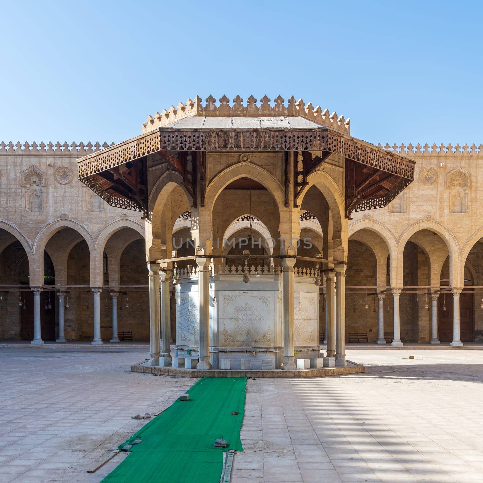 Ablution fountain mediating the courtyard of public historic mosque of Sultan al Muayyad, with background of arched corridor, Cairo, Egypt