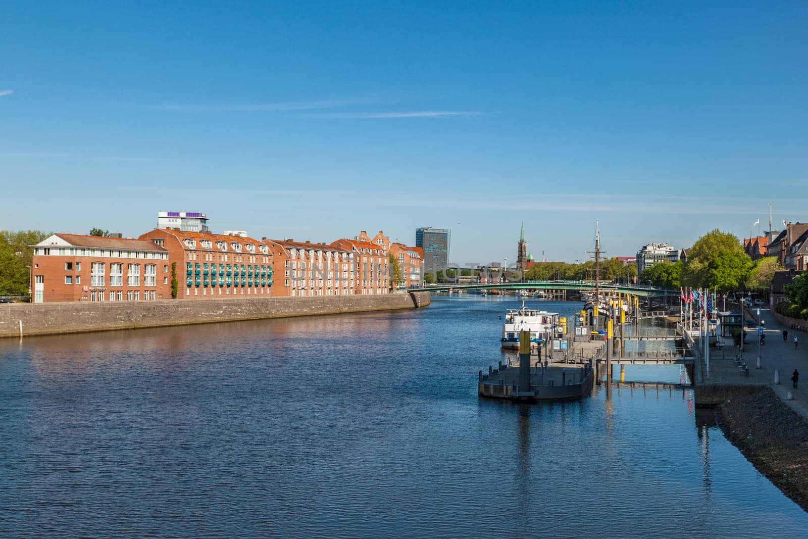 BREMEN, GERMANY - MAY 13, 2016: Cityscape with Teerhof on the left and view to the bridge at river Weser. The Weser is a main transportation route for Bremen.
