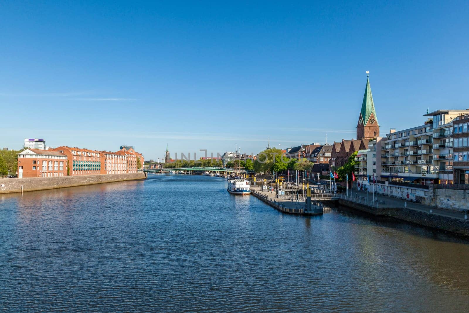 BREMEN, GERMANY - MAY 13, 2016: Cityscape with Teerhof on the left and view to the bridge at river Weser. The Weser is a main transportation route for Bremen.