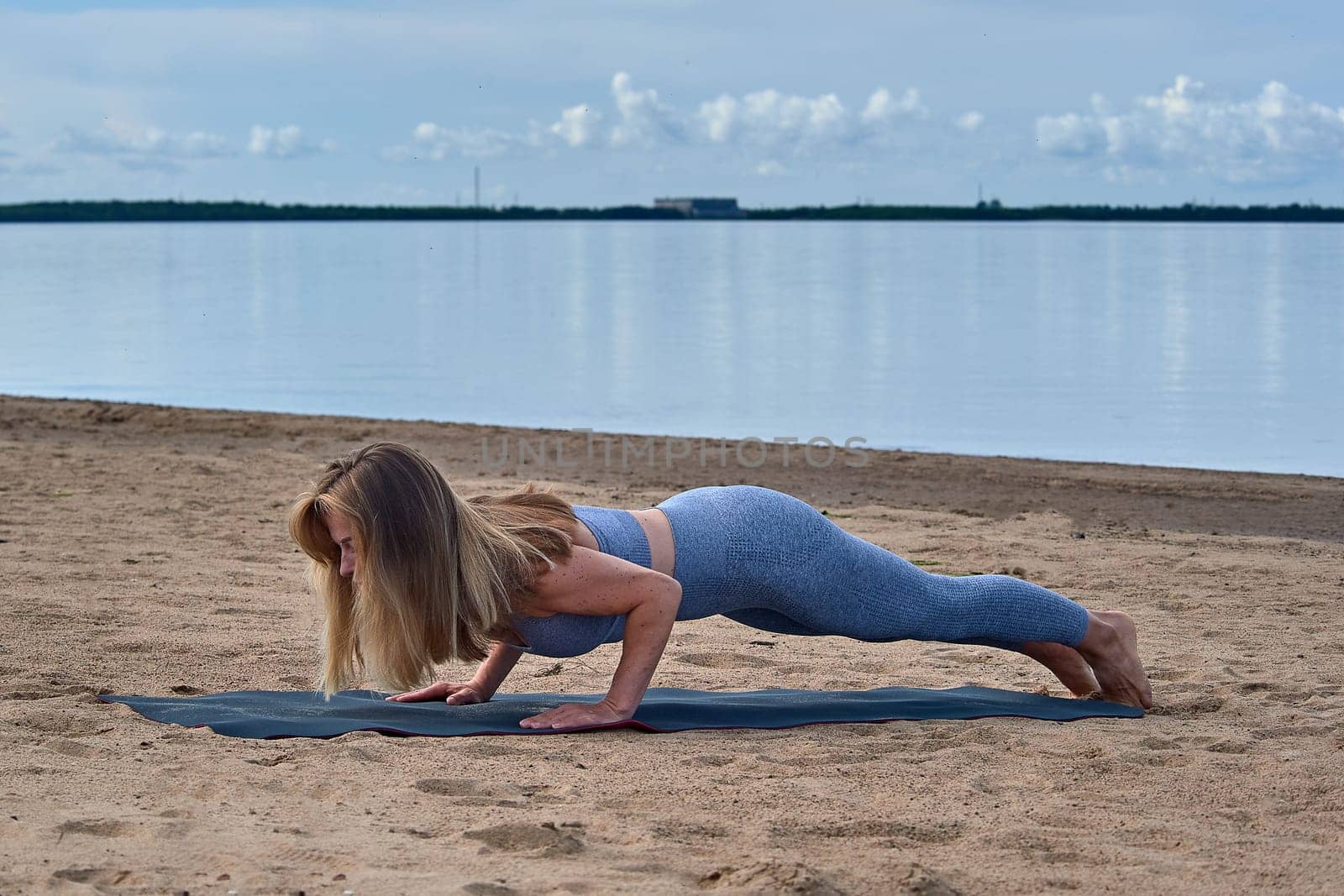 Woman doing yoga on the sandy beach. High quality photo