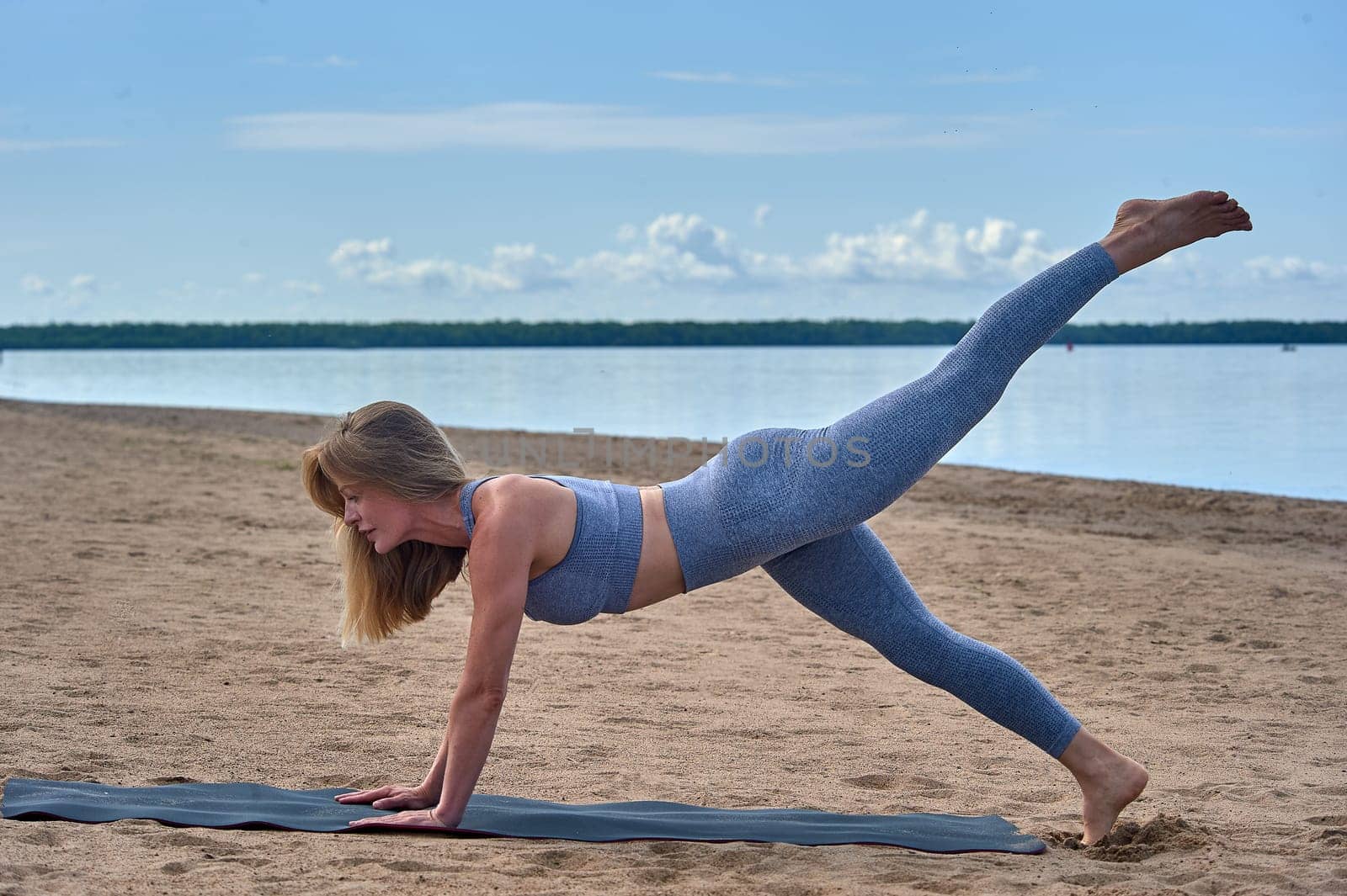 Woman doing yoga on the sandy beach. High quality photo