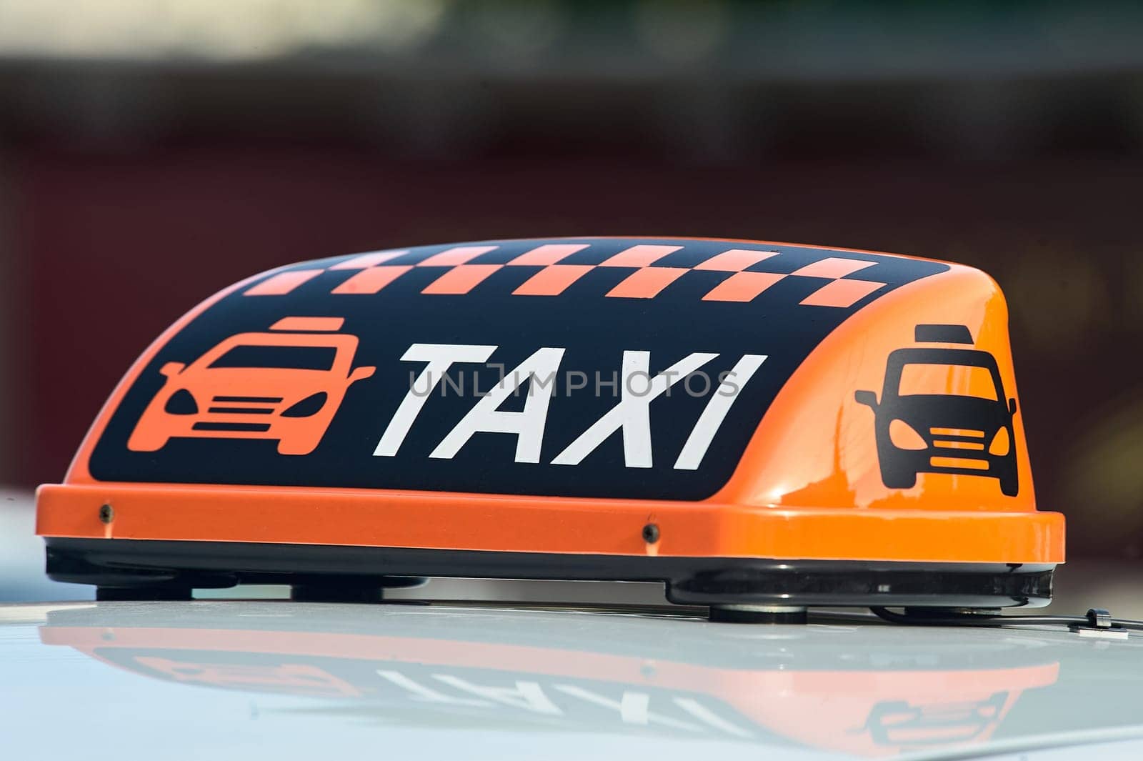 an orange taxi sign stands on the roof of the car. High quality photo