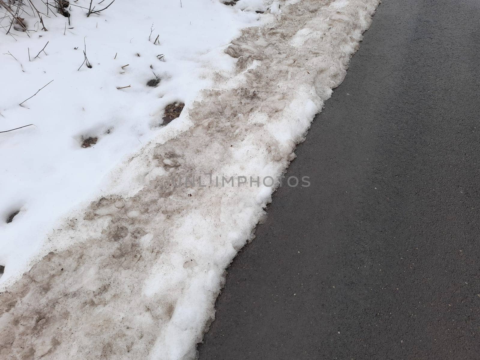 Snow removal with salt brine, dirty snow slash on the roadside