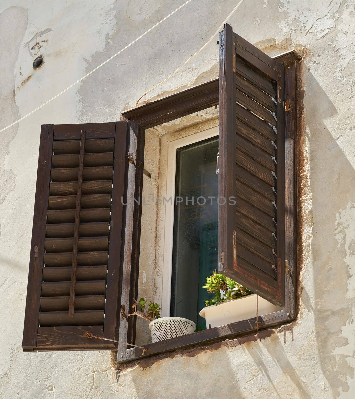 Window with shutter on the facade of a historic house in the old town of Rab in Croatia