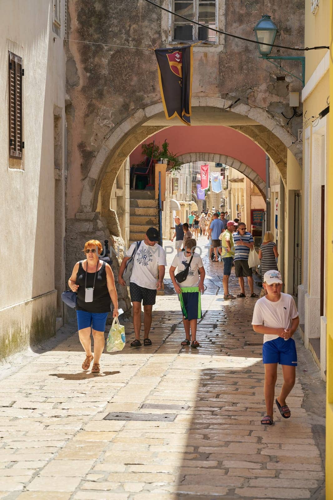 Tourists in an alley in the old town of Rab on the island of the same name on the Adriatic Sea in Croatia