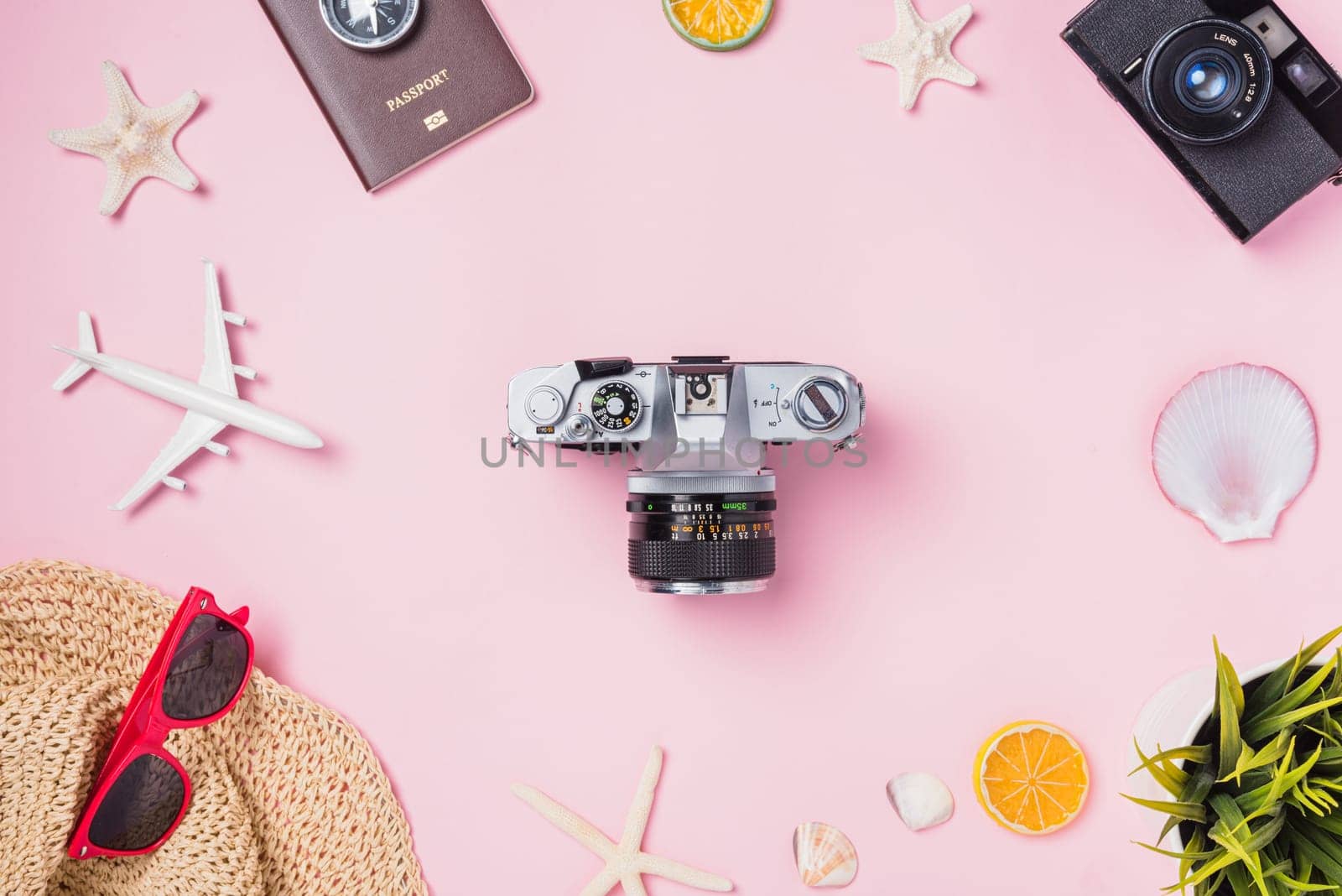 Top view flat lay mockup of retro camera films, airplane, starfish, hat and traveler tropical accessories isolated on pink background with copy space, Business trip, and vacation summer travel concept