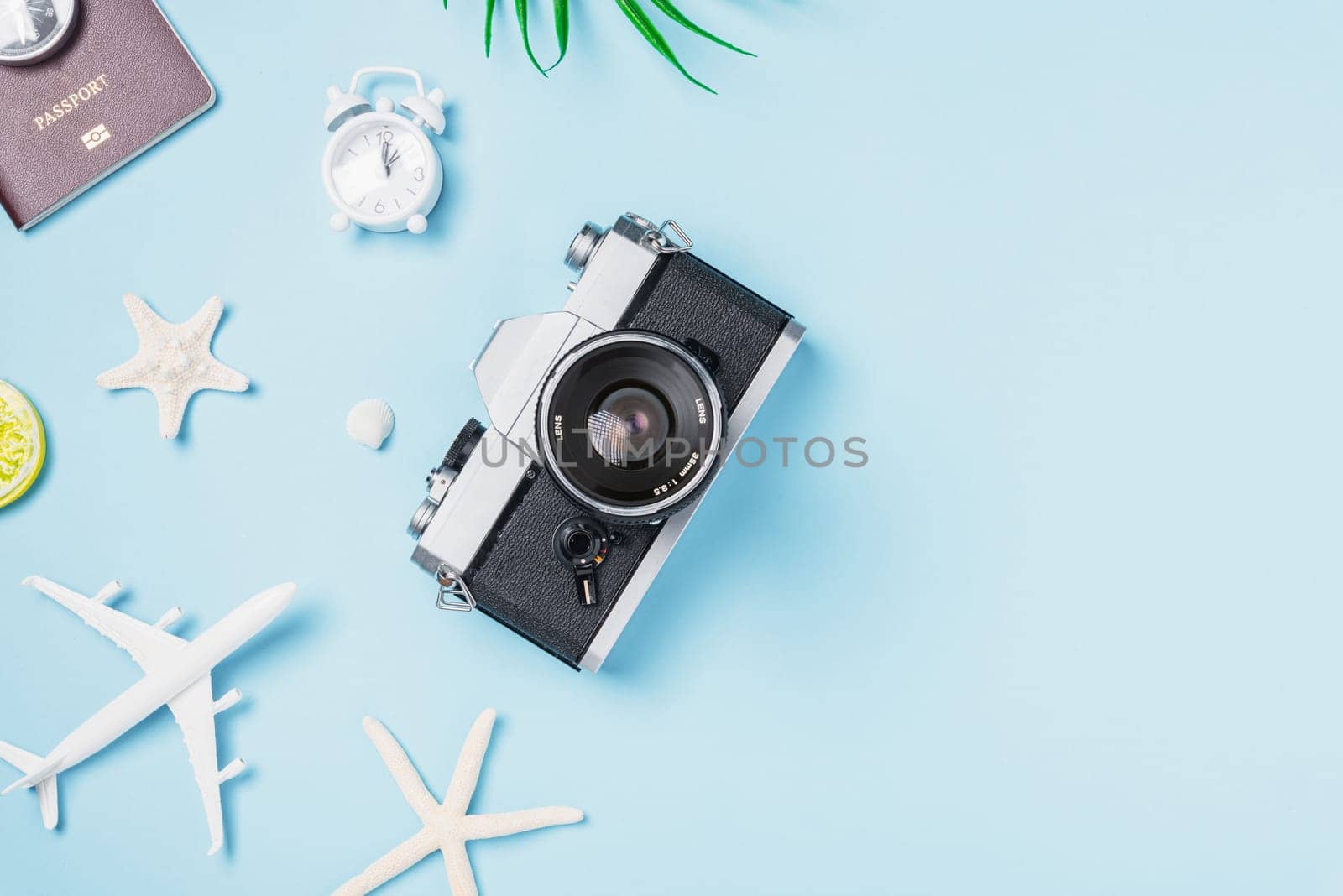 Flat lay top view mockup retro camera films, airplane, passport, starfish, shells traveler tropical accessories on a blue background with copy space, Vacation summer travel and business trip concept