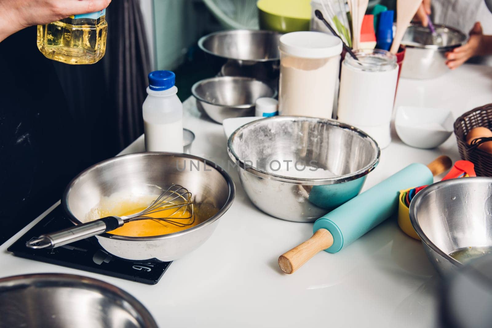 Woman during making pouring oil before cooking bakery cake at homemade