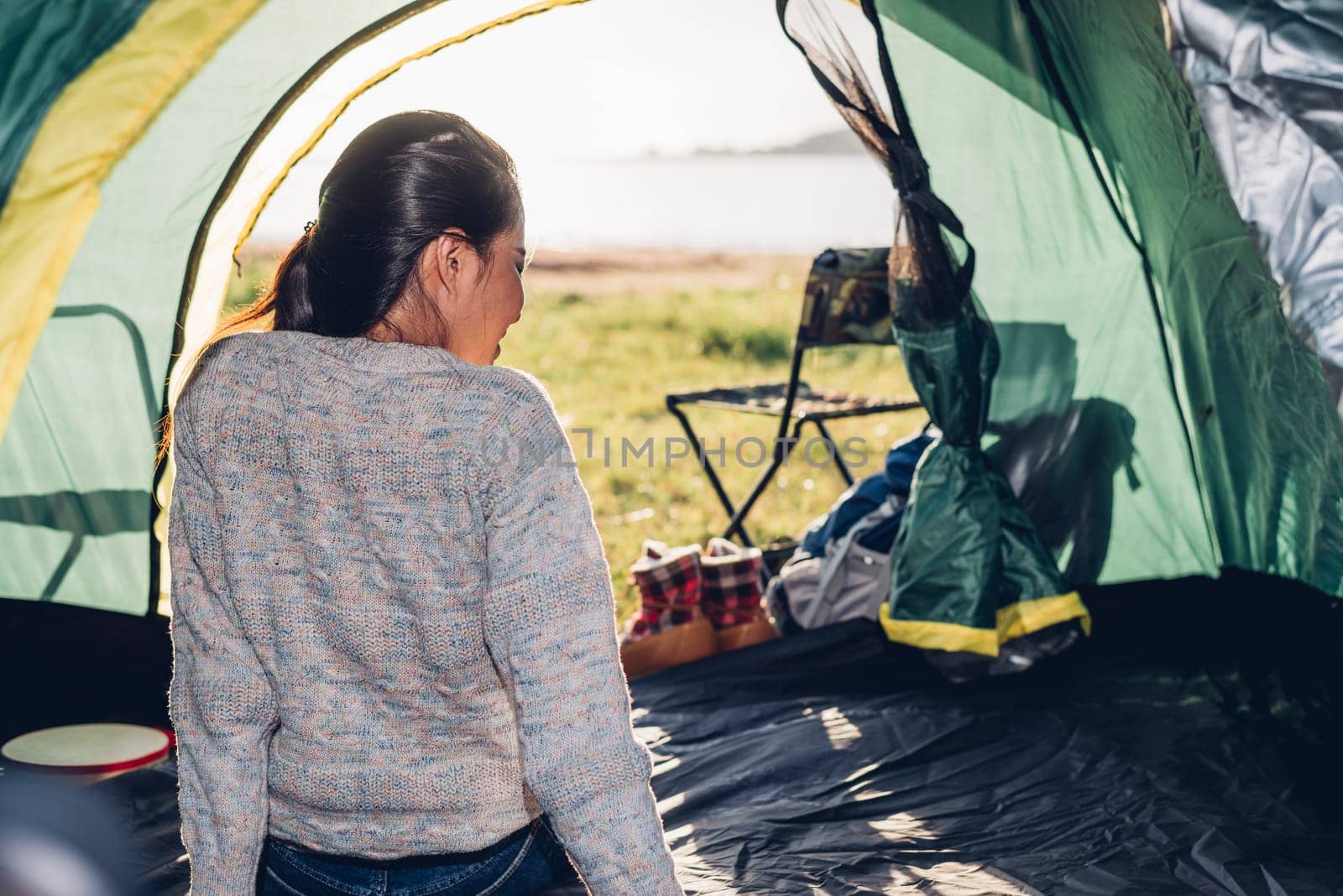 Young woman sitting looking out camping tent on travel outdoor holiday summer