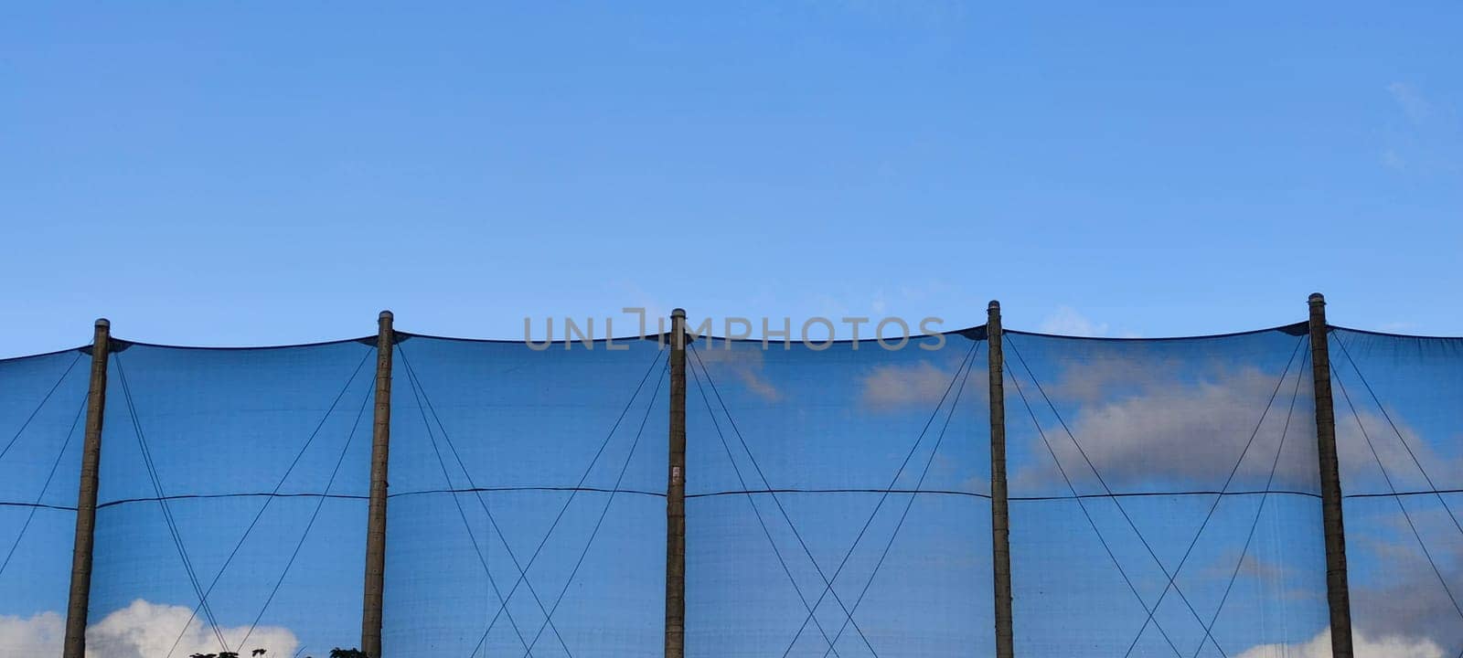 The net against blue sky. Beautiful cirrus clouds. Beautiful cirrus clouds over the sports field