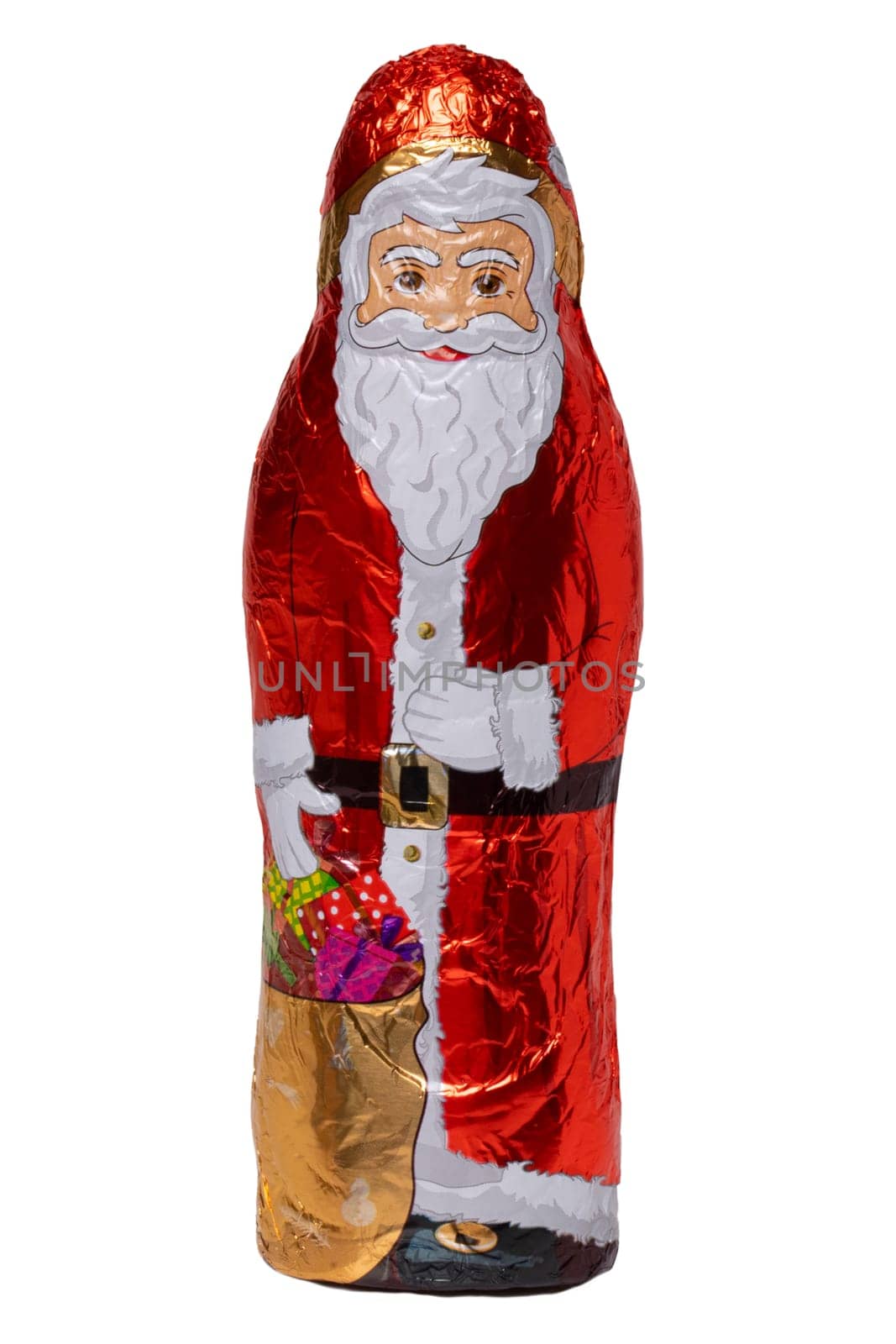 Chocolate Santa isolated. Close-up of a cheerful wrapped chocolate Father Christmas or the good Saint Nicholas figure isolated on a white background. Macro photography.