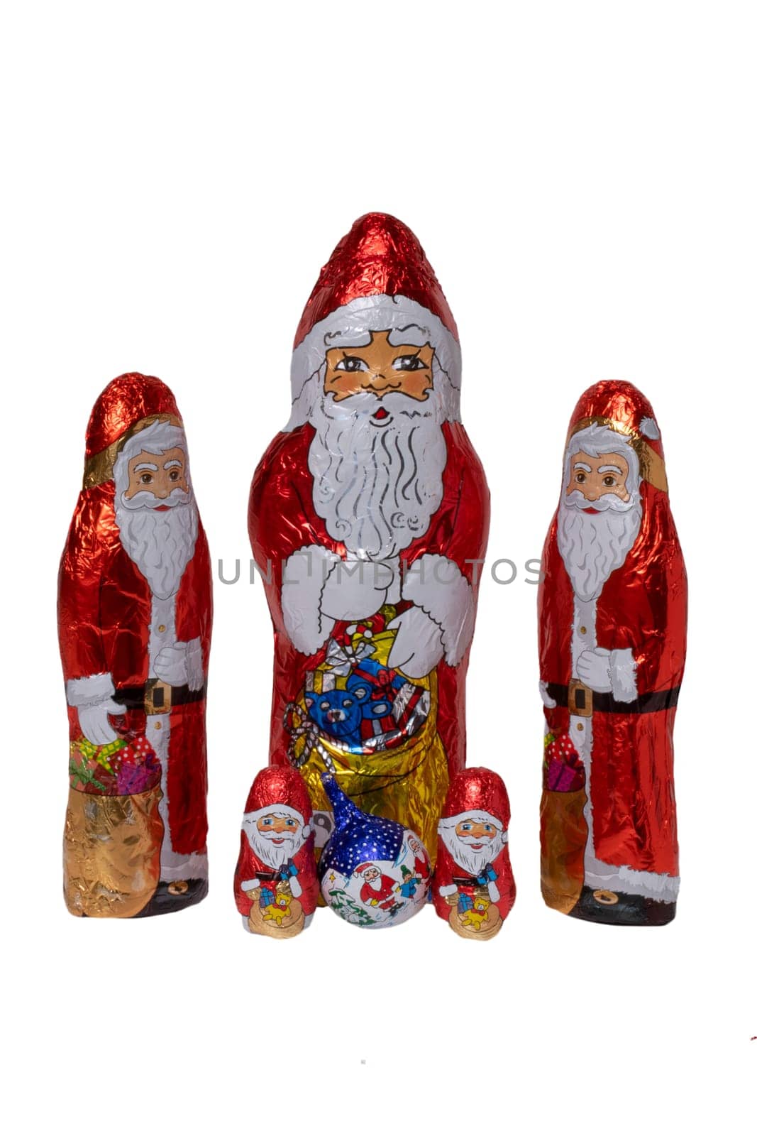 Chocolate Santa isolated. Close-up of five cheerful wrapped chocolate Santa Claus or the good Saint Nicolas figurine isolated on a white background. Macro photograph.