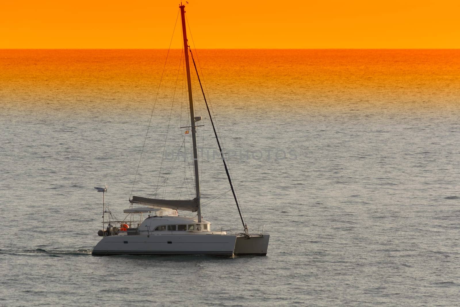 Yacht - catamaran in the tropical sea at sunset. Yachting / luxury sailing theme