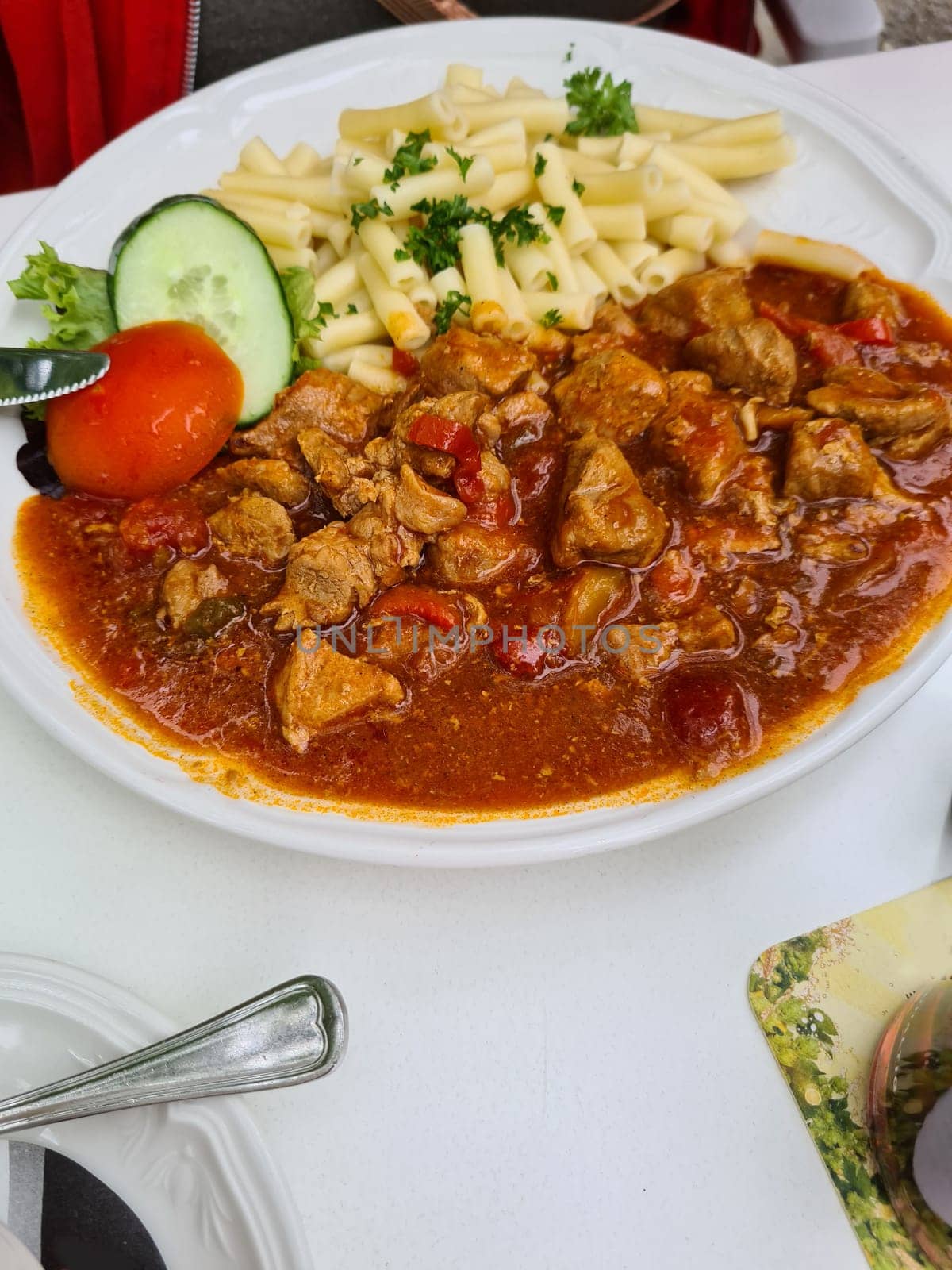Tasty stuffed beef chunks or beef stroganoff with pasta fussili served on plate. View from above.