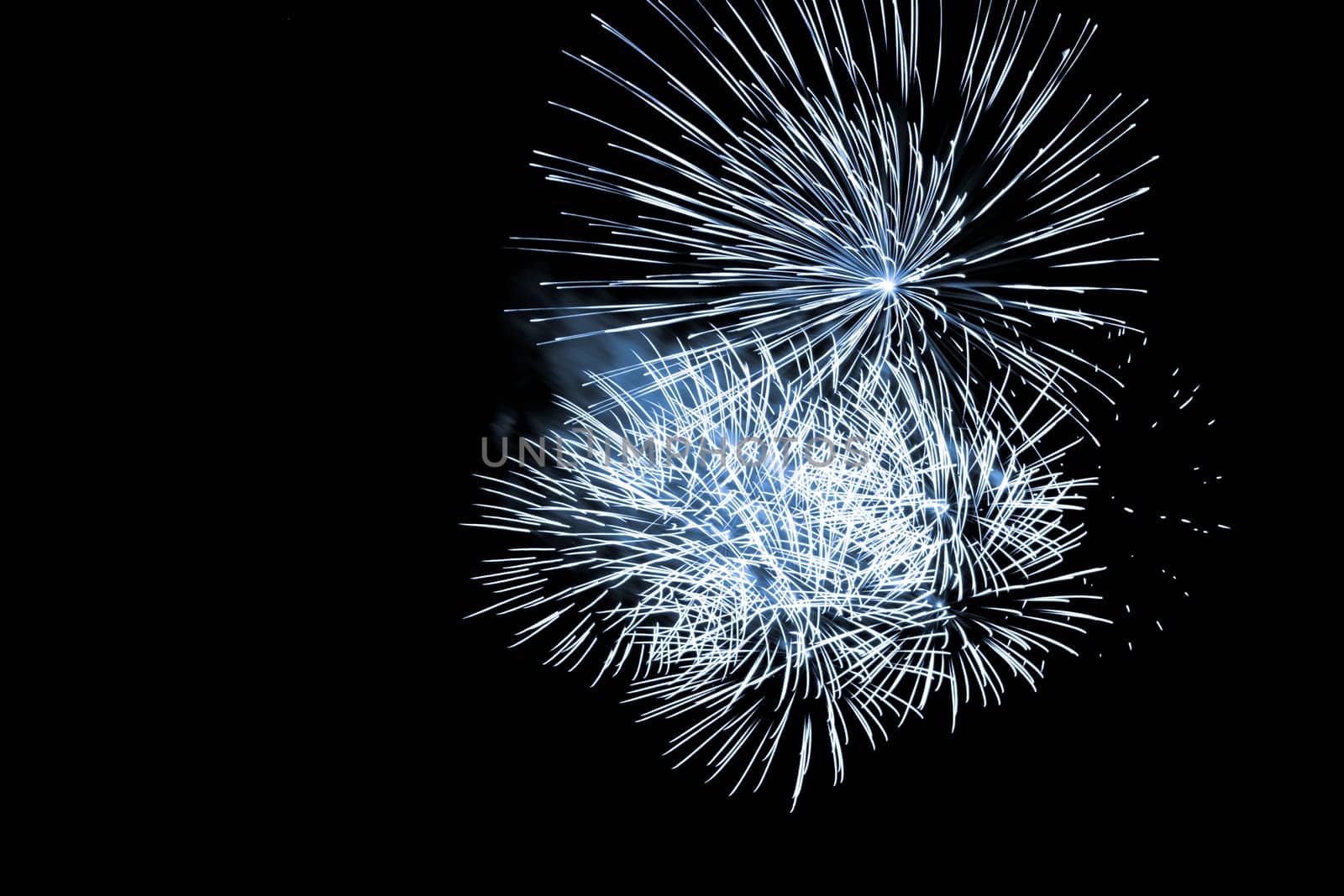 Premium entertainment magic star firework at e.g. New Years Eve or Independence Day party celebration. Black dark night background.