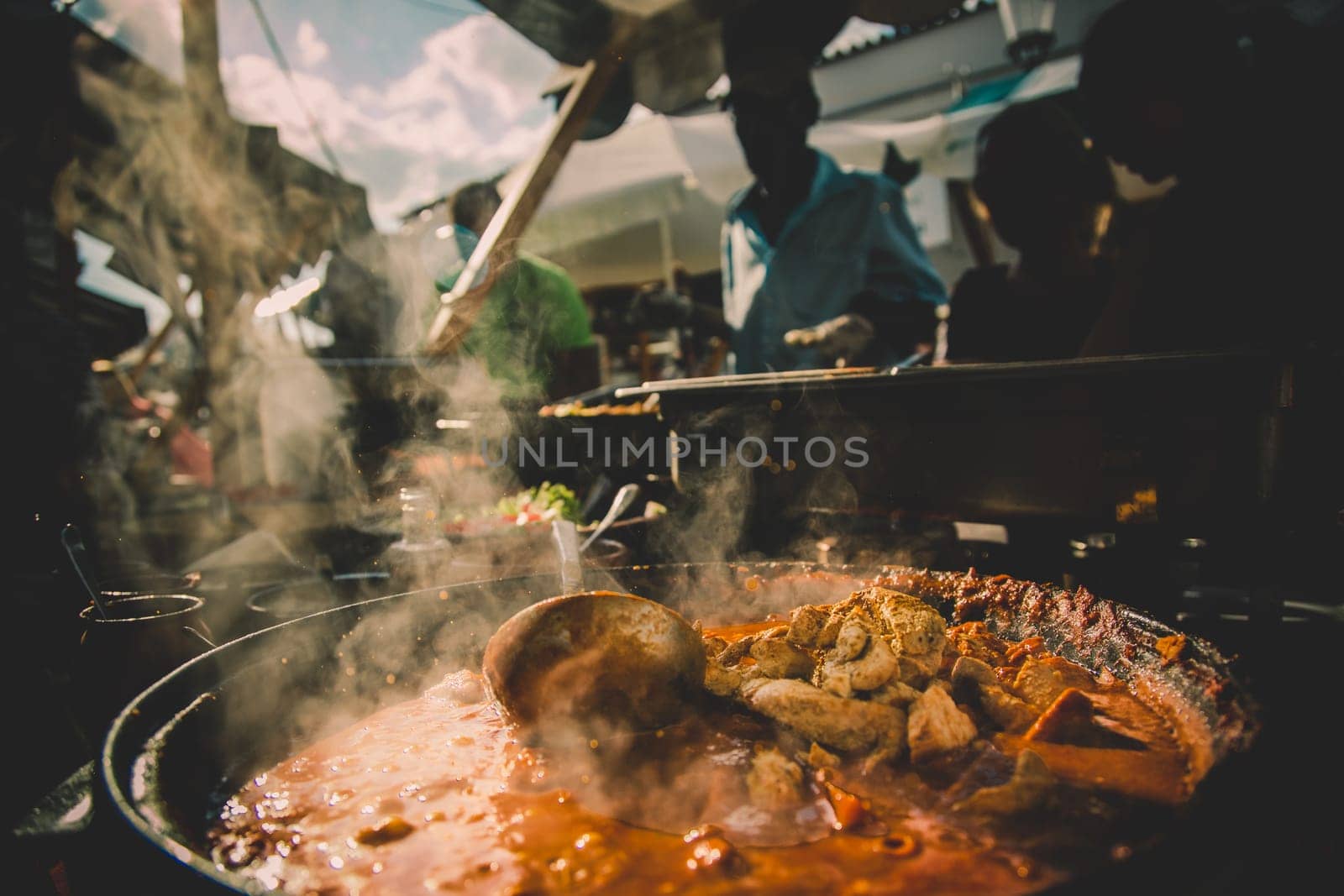 Cheff serving fusion international cusine on street stall on international street food festival of Odprta kuhna, Open kitchen event, in Ljubljana, Slovenia.