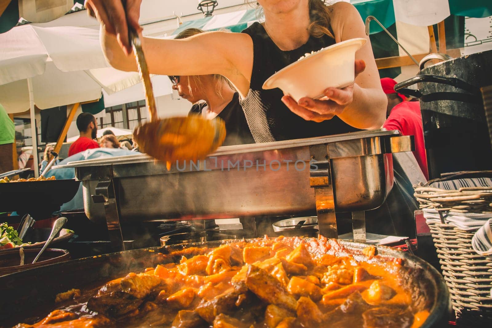 Cheff serving fusion international cusine on street stall on international street food festival of Odprta kuhna, Open kitchen event, in Ljubljana, Slovenia.