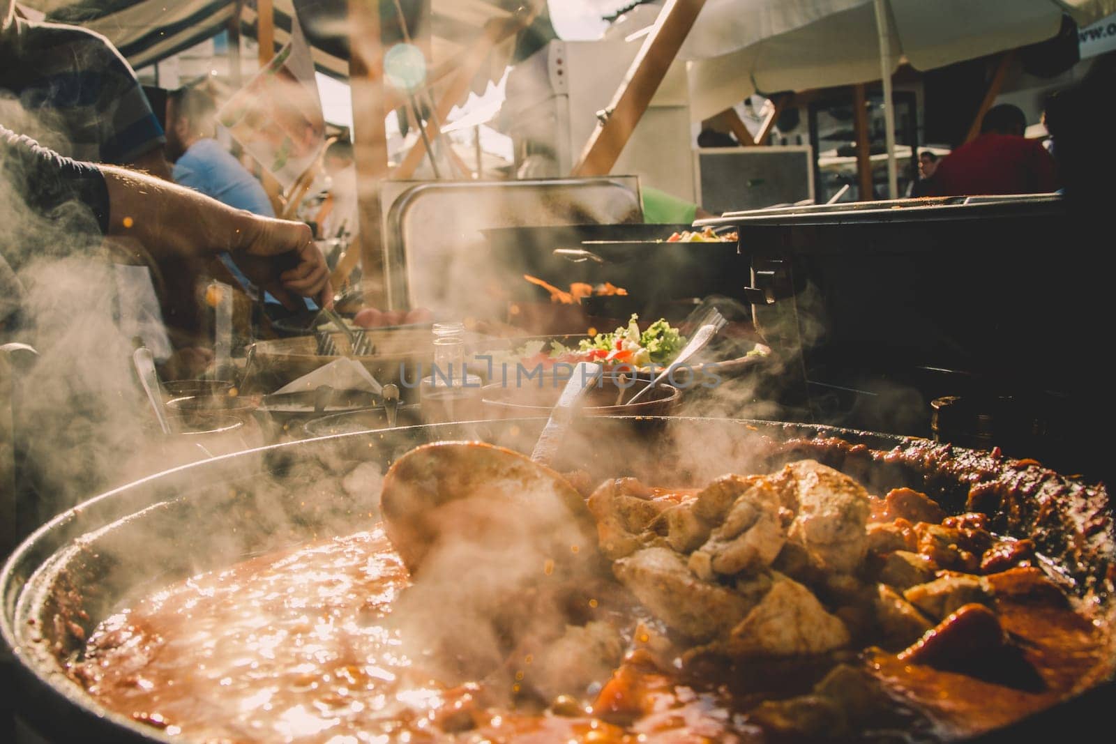 Cheff serving fusion international cusine on street stall on international street food festival of Odprta kuhna, Open kitchen event, in Ljubljana, Slovenia.