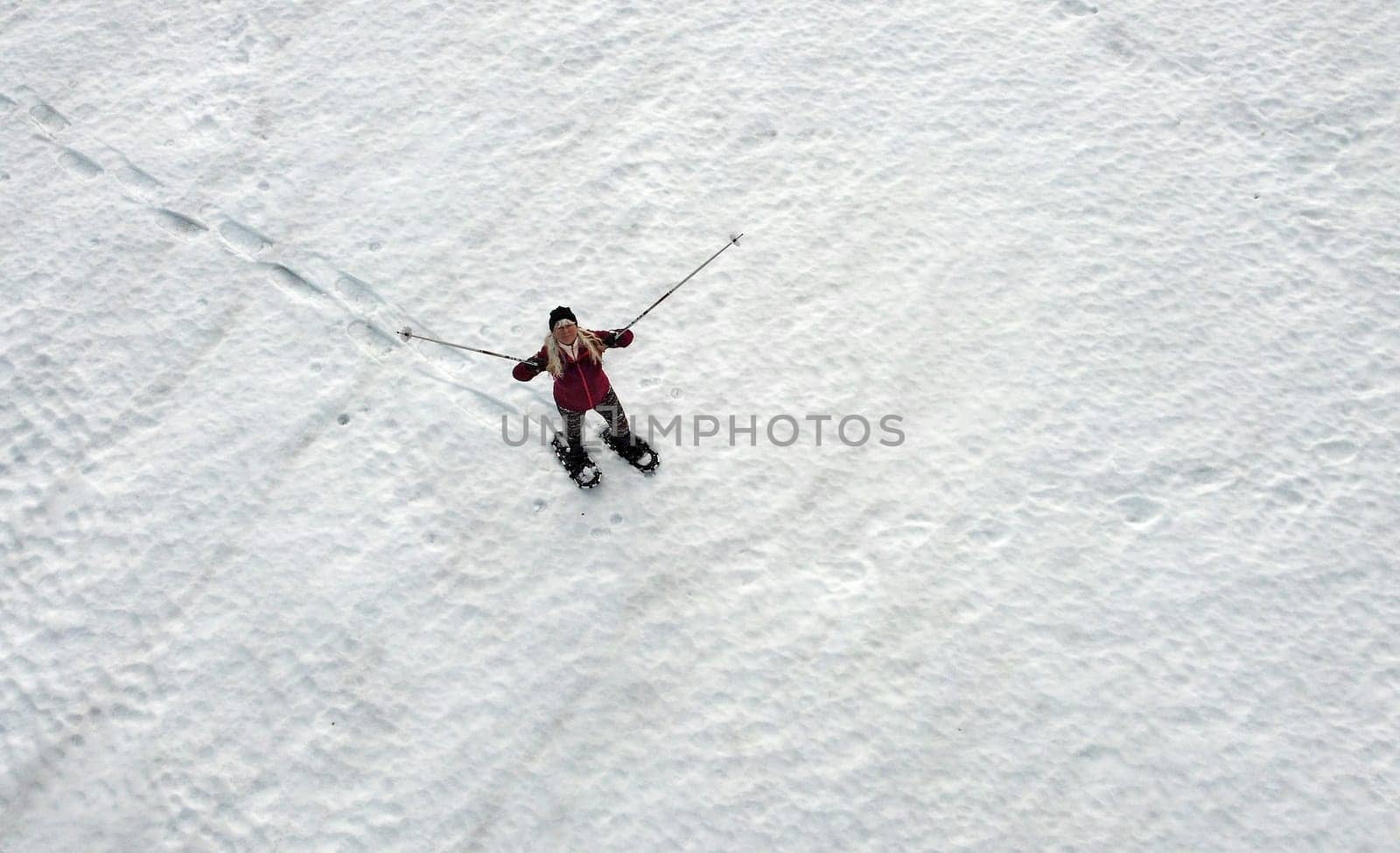 A woman walks in winter with snowshoes
