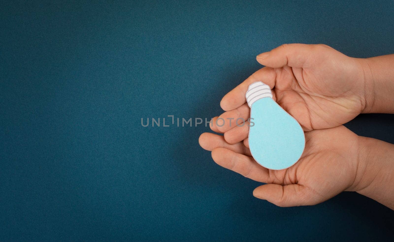 Holding a light bulb in the palm of the hand, creative concept, having new ideas, brainstorming for strategy, start up business