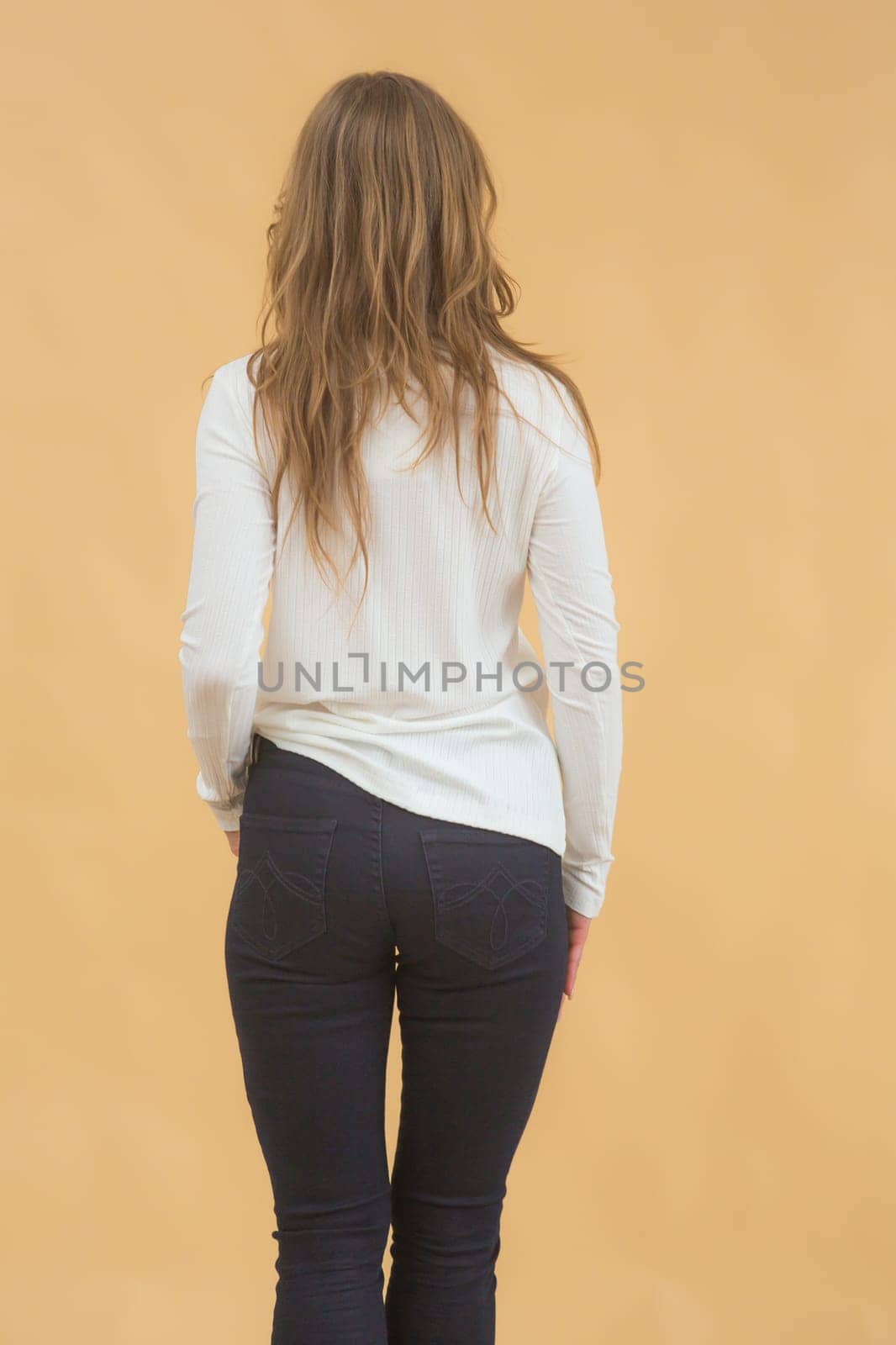 A woman in clothes on the background in the studio, fitting clothes.