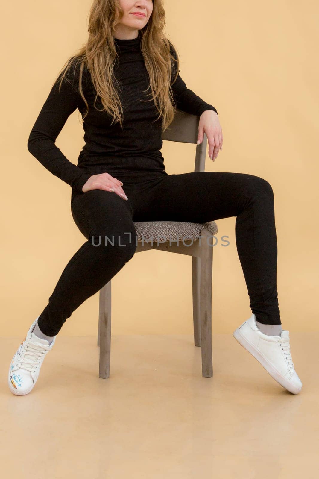 A woman in clothes on the background in the studio, fitting clothes.