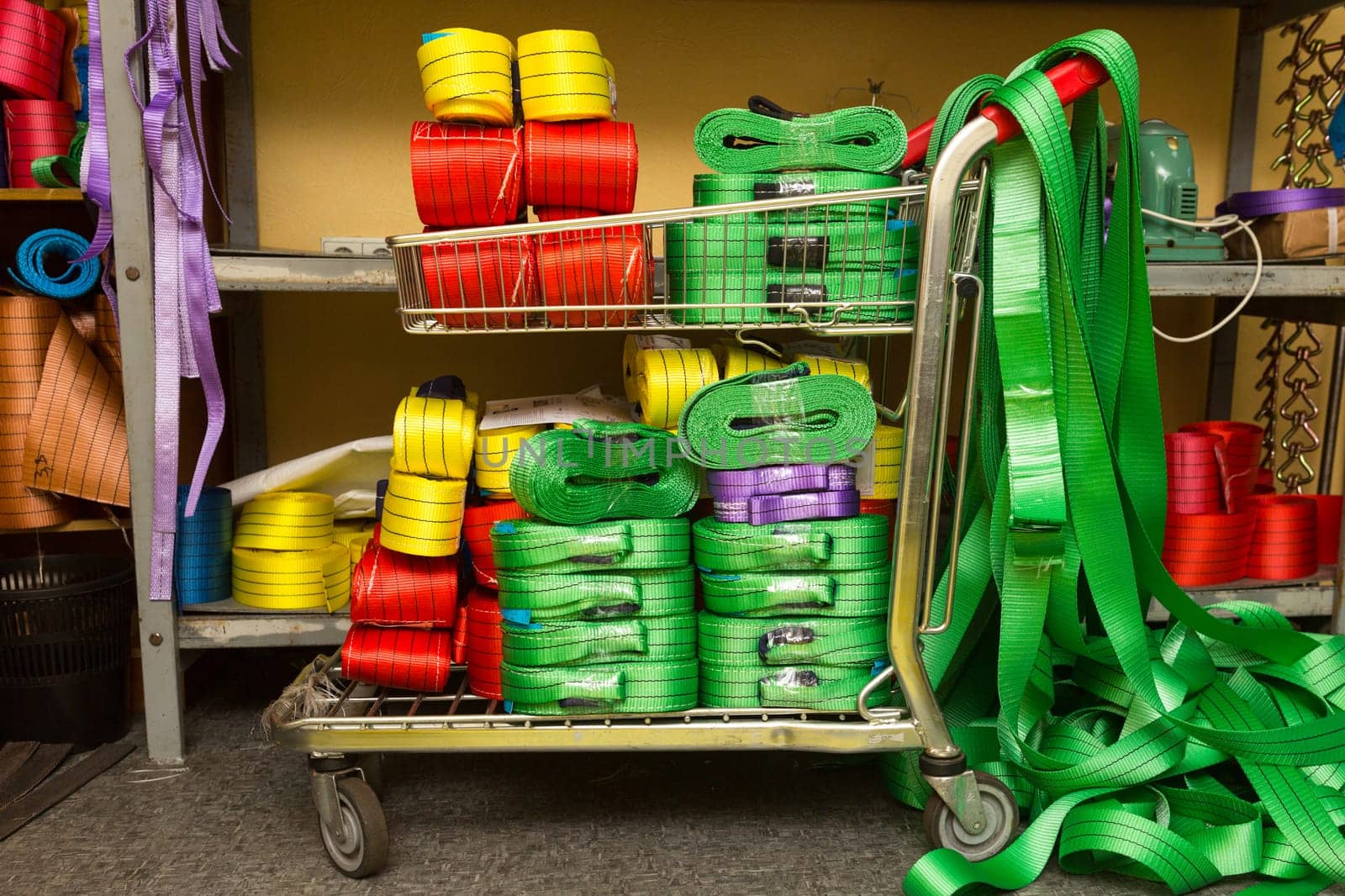 Industrial sewing machine sews a webbing sling. Manufacture of textile slings and tie straps
