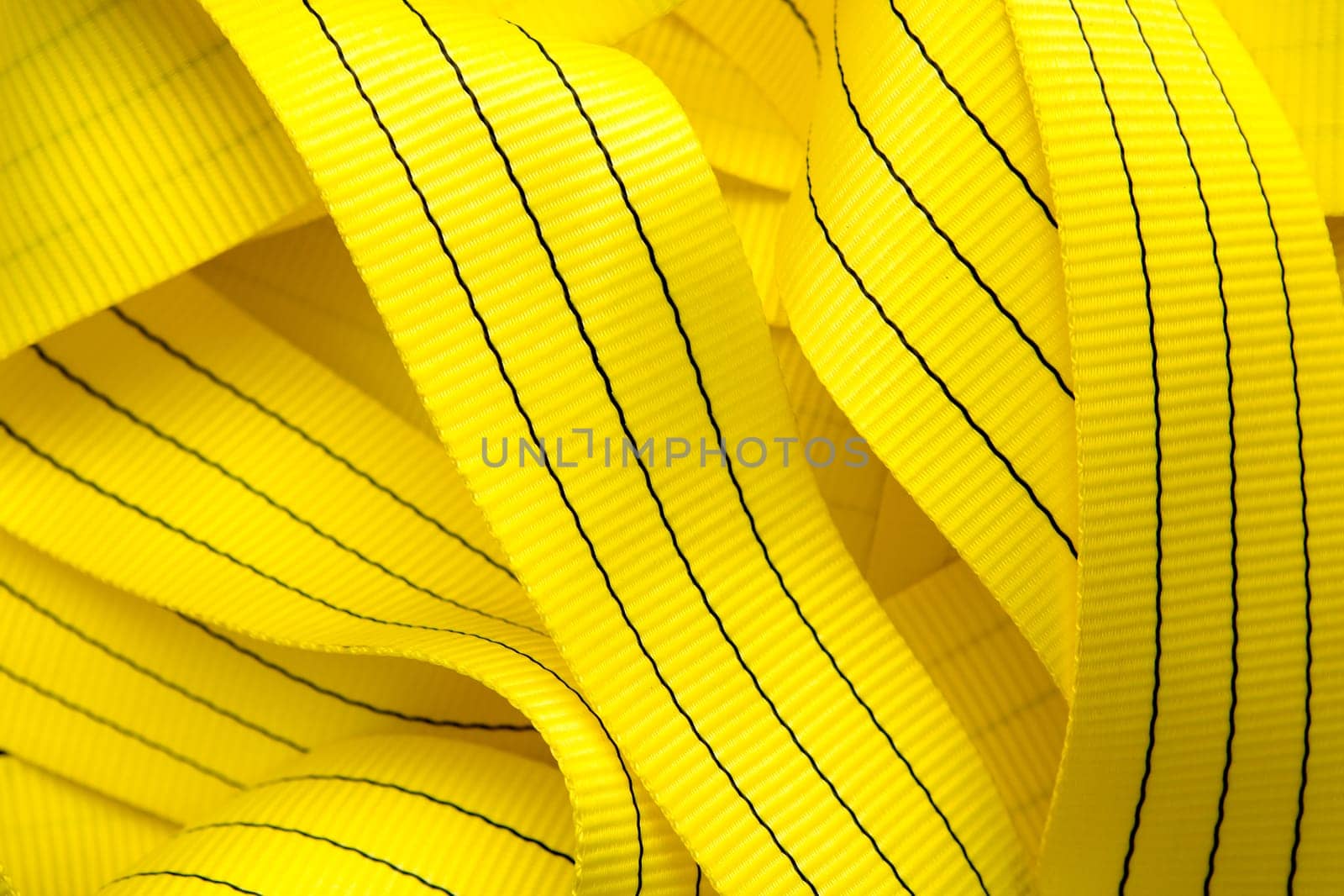Industrial sewing machine sews a webbing sling. Manufacture of textile slings and tie straps