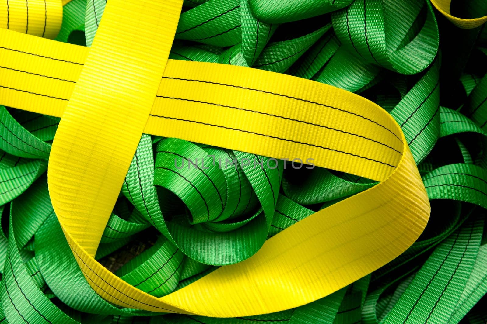 Industrial sewing machine sews a webbing sling. Manufacture of textile slings and tie straps
