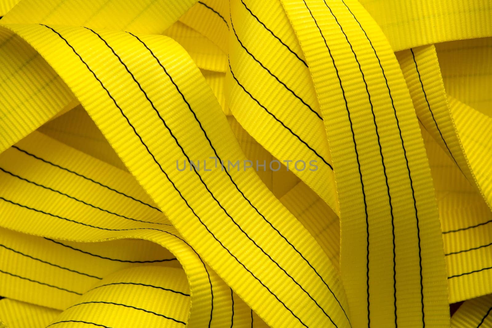 Industrial sewing machine sews a webbing sling. Manufacture of textile slings and tie straps