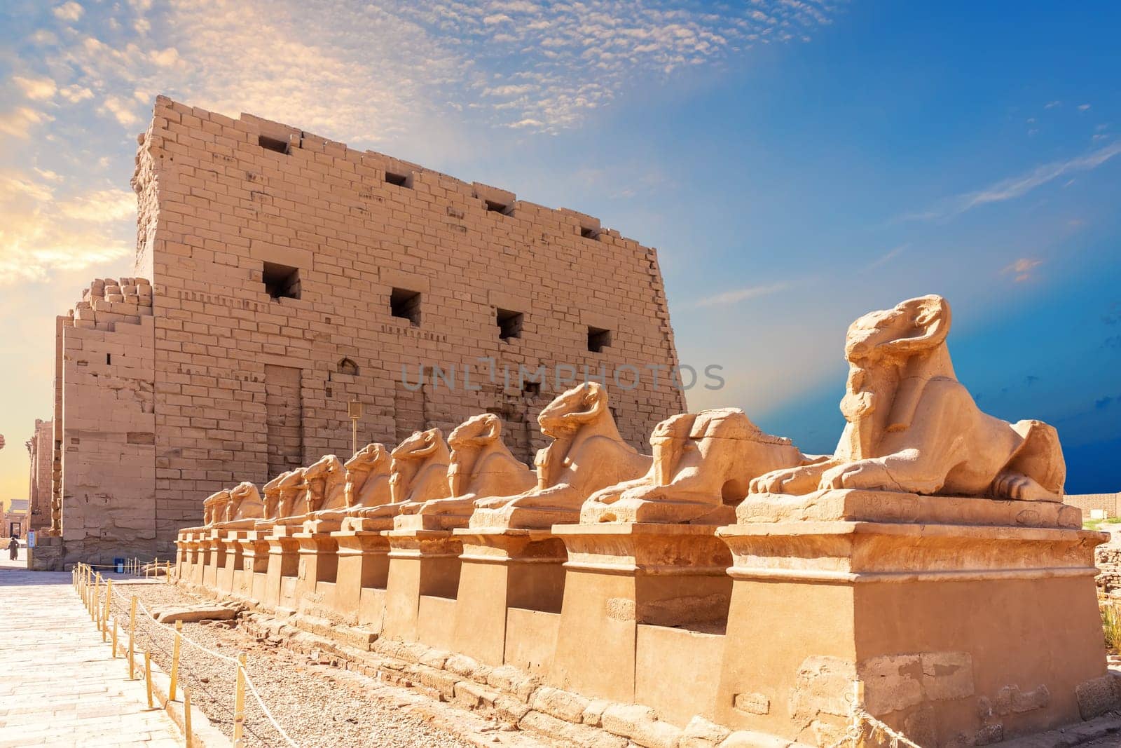 Avenue of ram-headed Sphinxes and the wall of Karnak Temple, Luxor, Egypt.