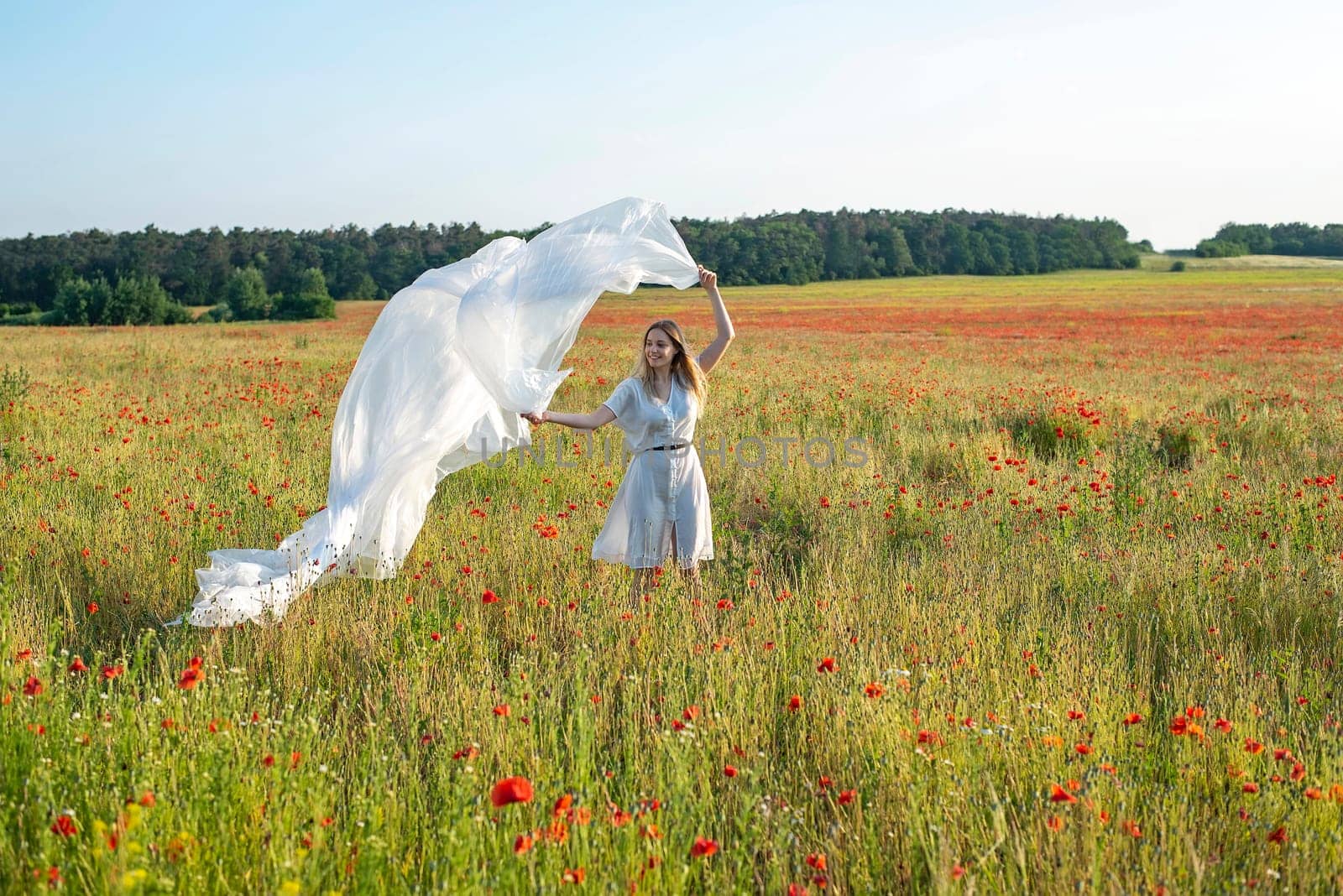 happy young woman with foil in poppy field