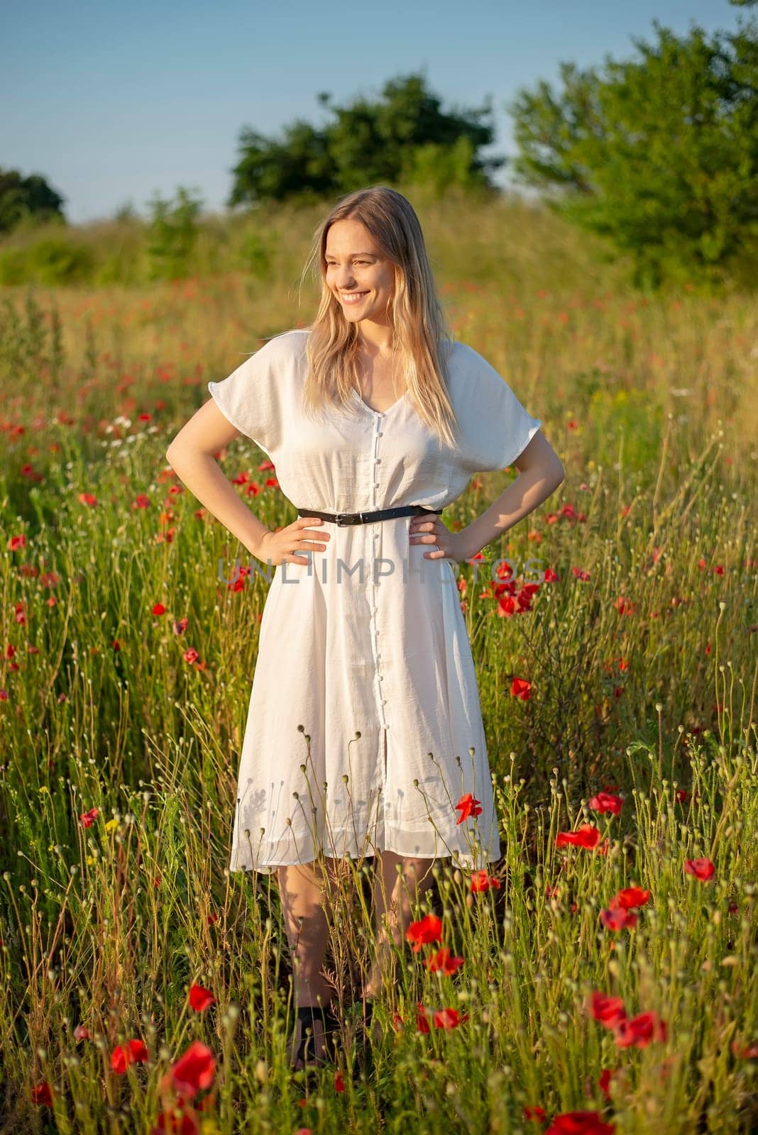 pretty young woman enjoying sun in poppy field