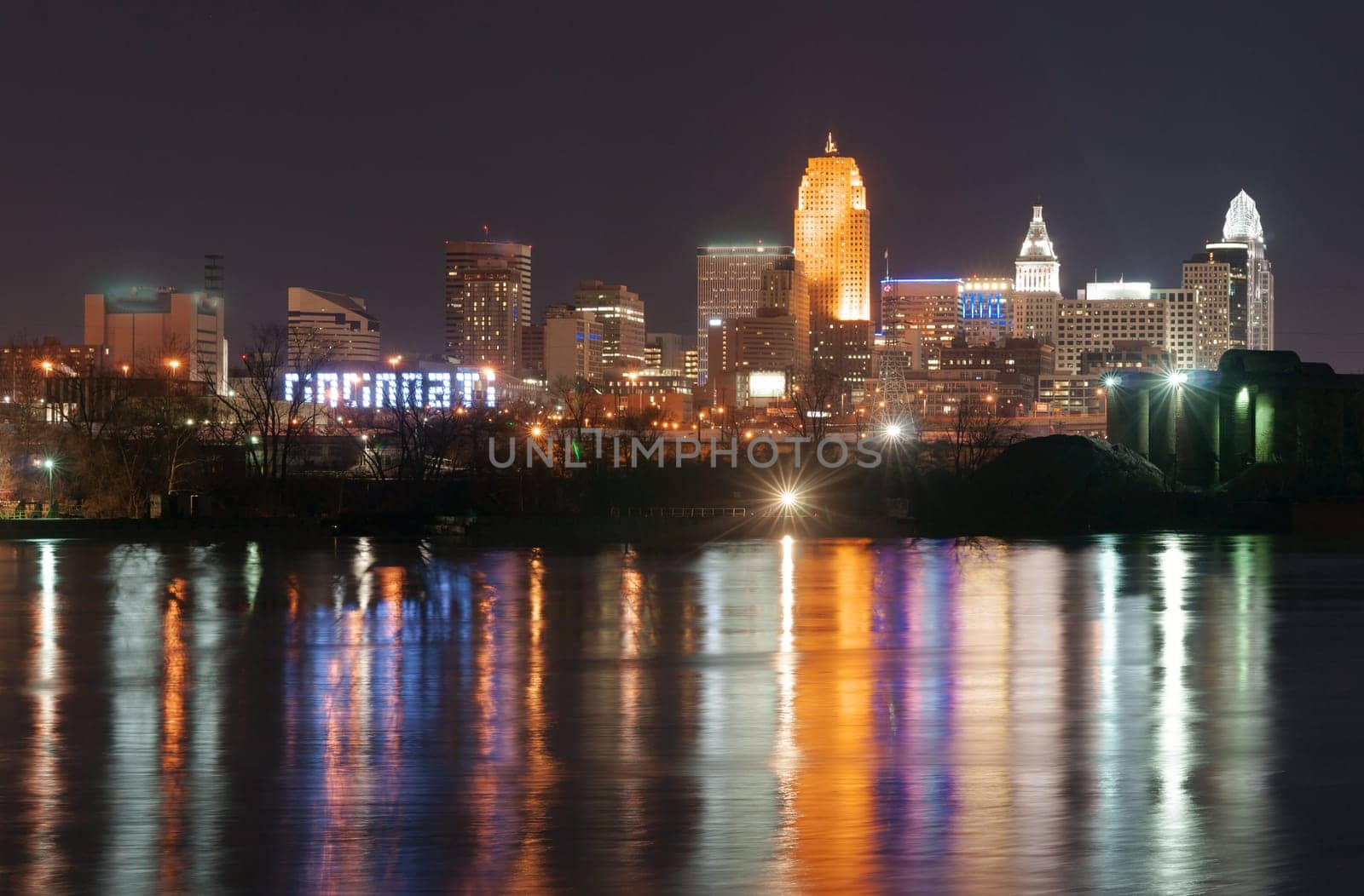 Office buildings light are reflected in the flowing river called Ohio
